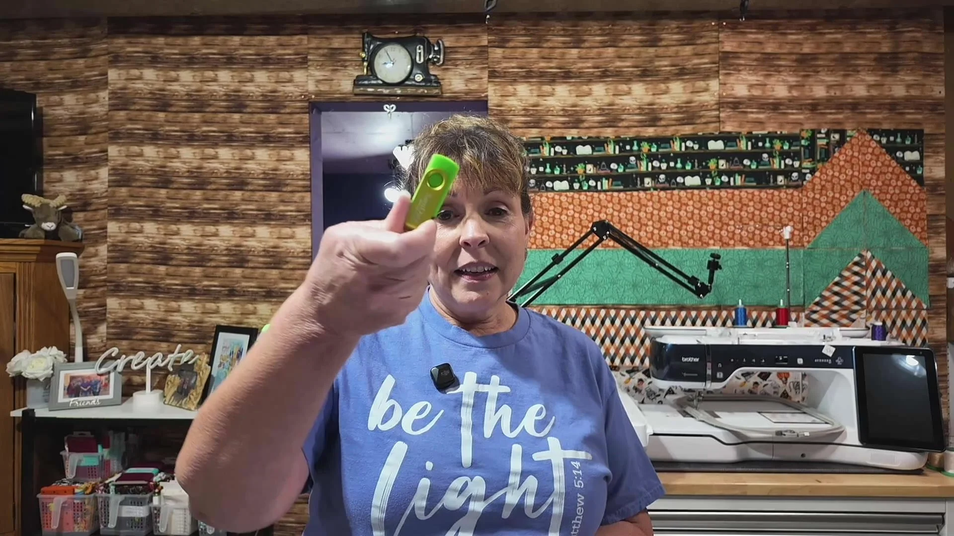 April holding a green USB thumb drive in her craft room during her APQS Quilt Path digital-files tutorial.