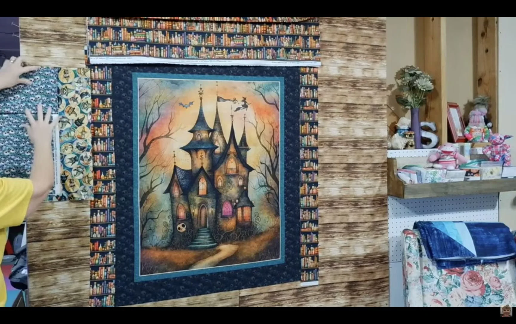 Haunted house quilt panel on April’s design wall with bookcase-print borders.