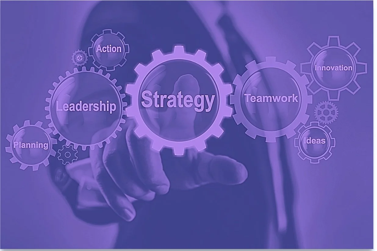 Business concept with words like "Strategy," "Leadership," "Planning," "Action," "Teamwork," "Innovation," and "Ideas" inside gear illustrations, with a person pointing at the center gear.
