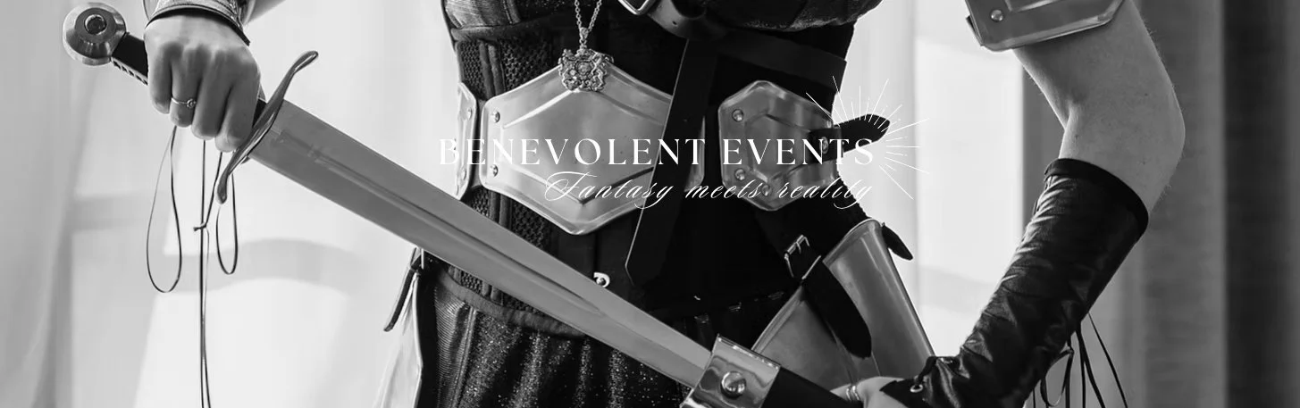 Person in costume holding a plastic sword, with a metal breastplate and black gloves, in black and white.