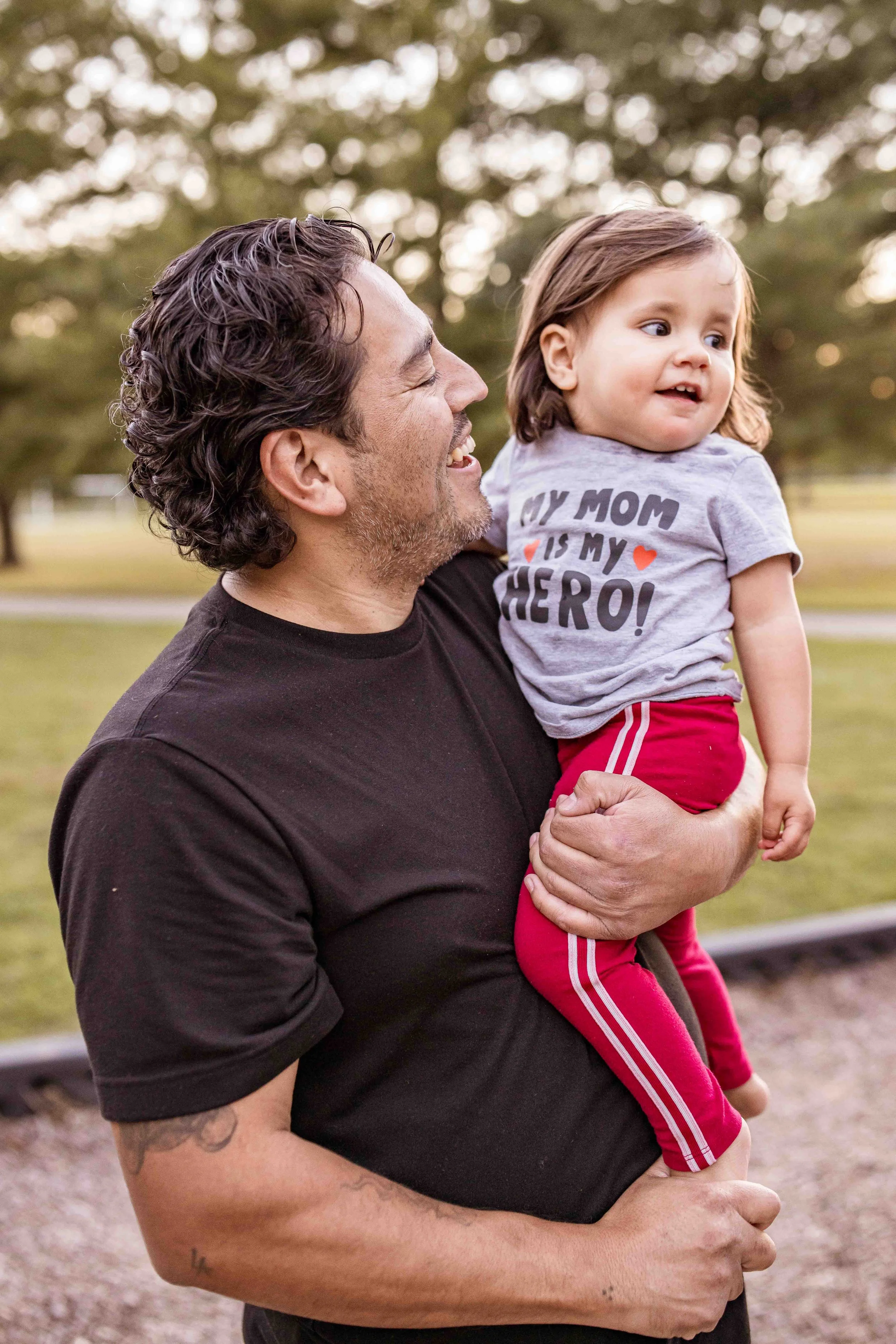 One of the best family photographers in Nashville holding his baby, capturing a heartfelt father-child moment that reflects his dedication to capturing authentic family connections.