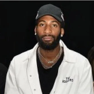 Man wearing a black cap, white jacket, and black shirt