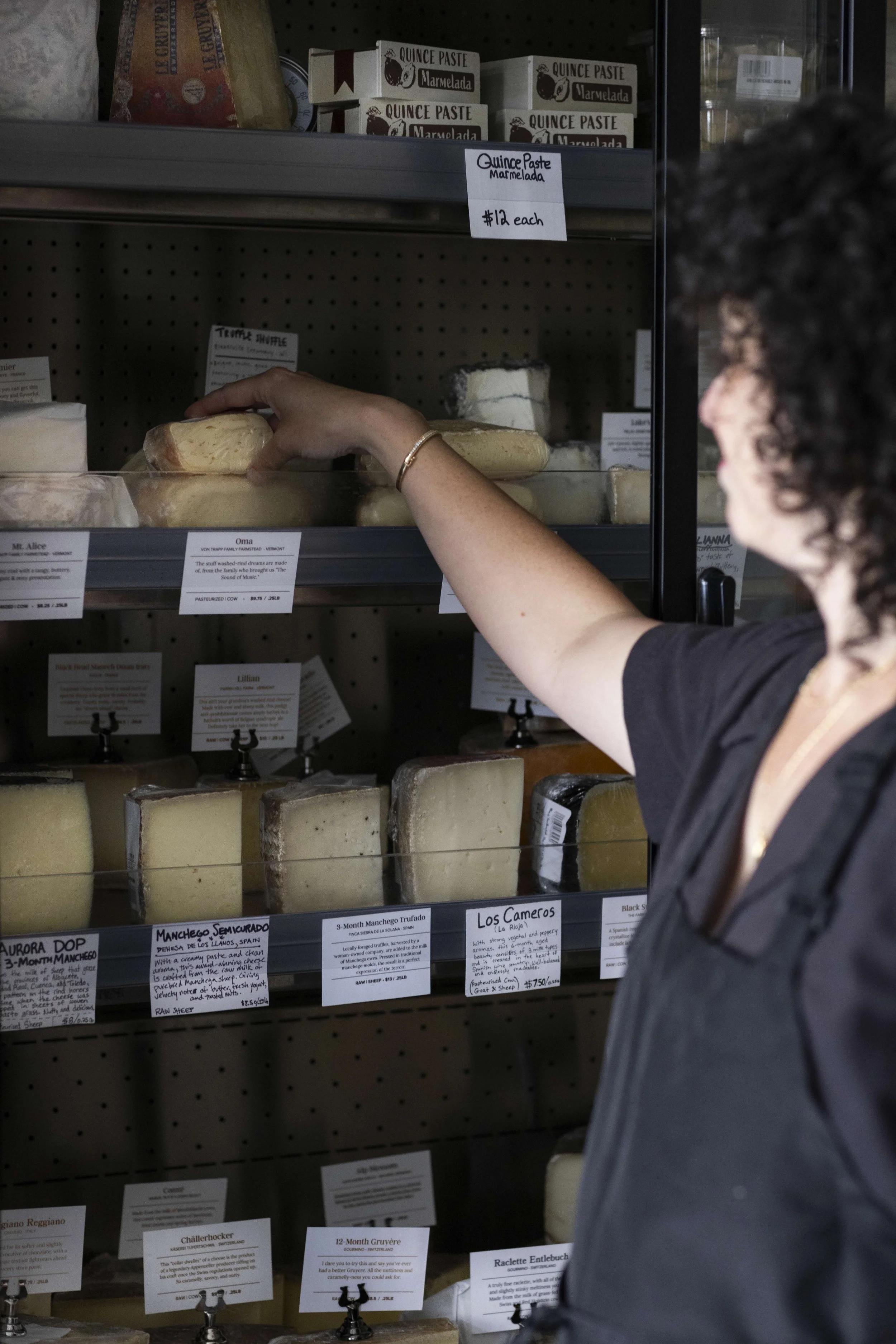 Owner Jessica Galen in front of cheese case. Frances F. Denny