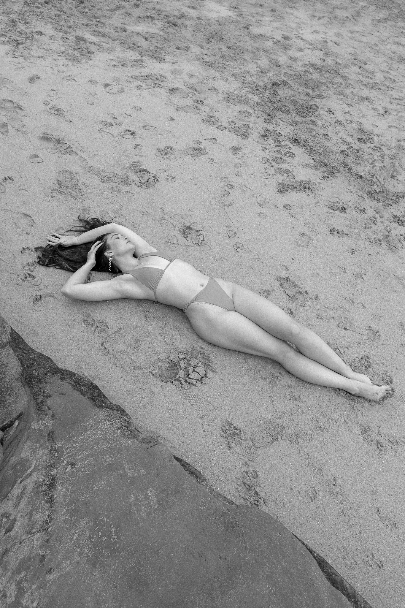 Person in a bikini lying on sandy beach