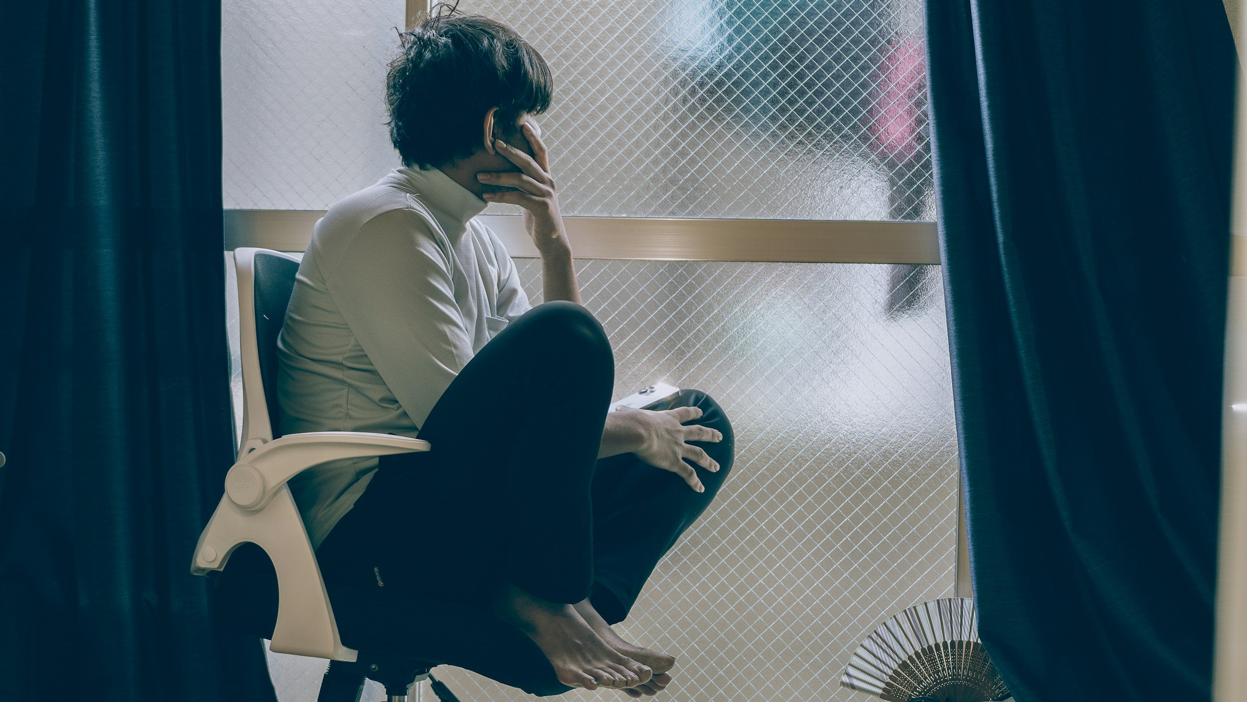Persoană îngrijorată lângă fereastră – anxietate și anxietate socială