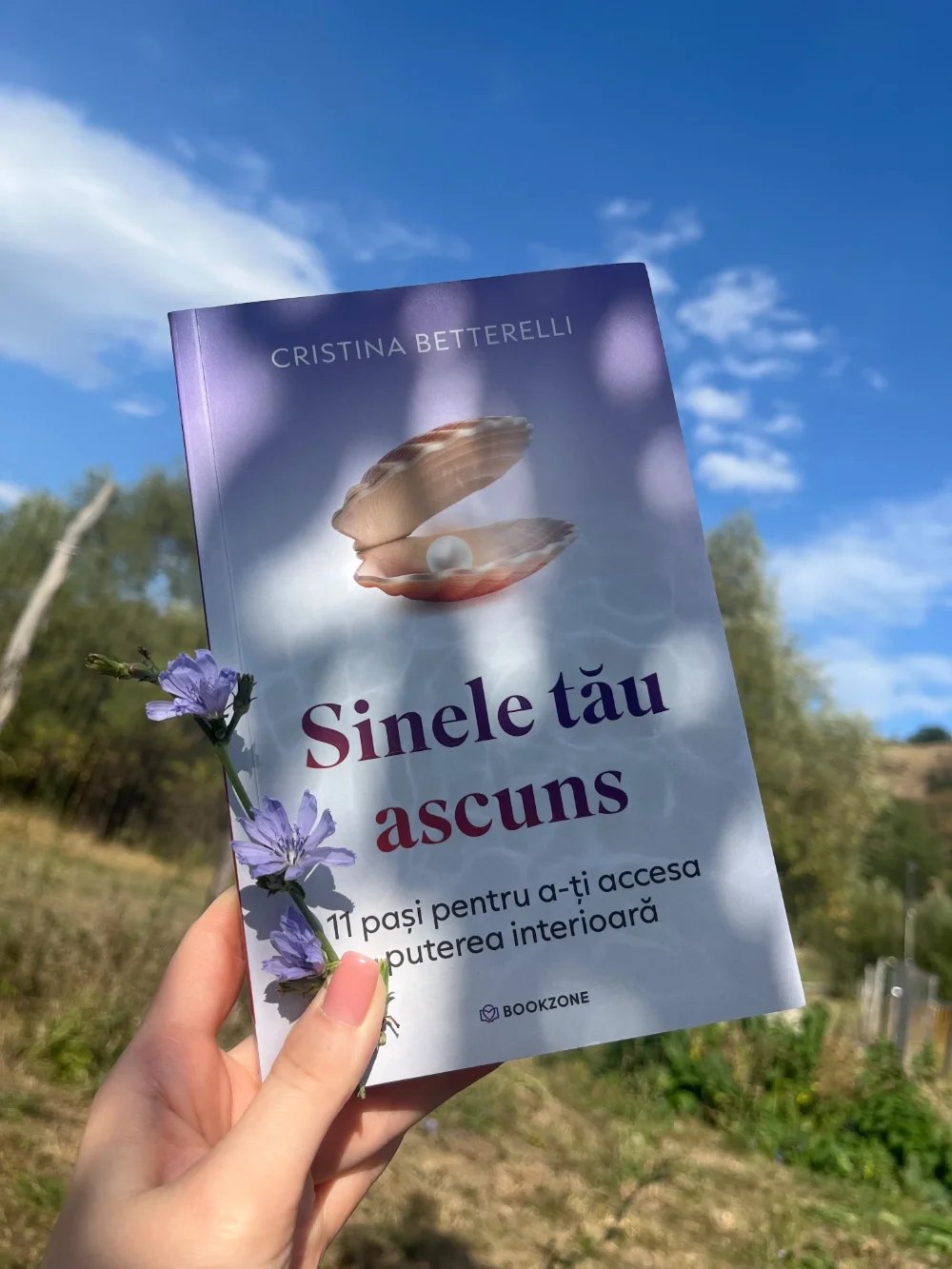 Cititor ținând în mână cartea „Sinele tău ascuns” de Cristina Betterelli