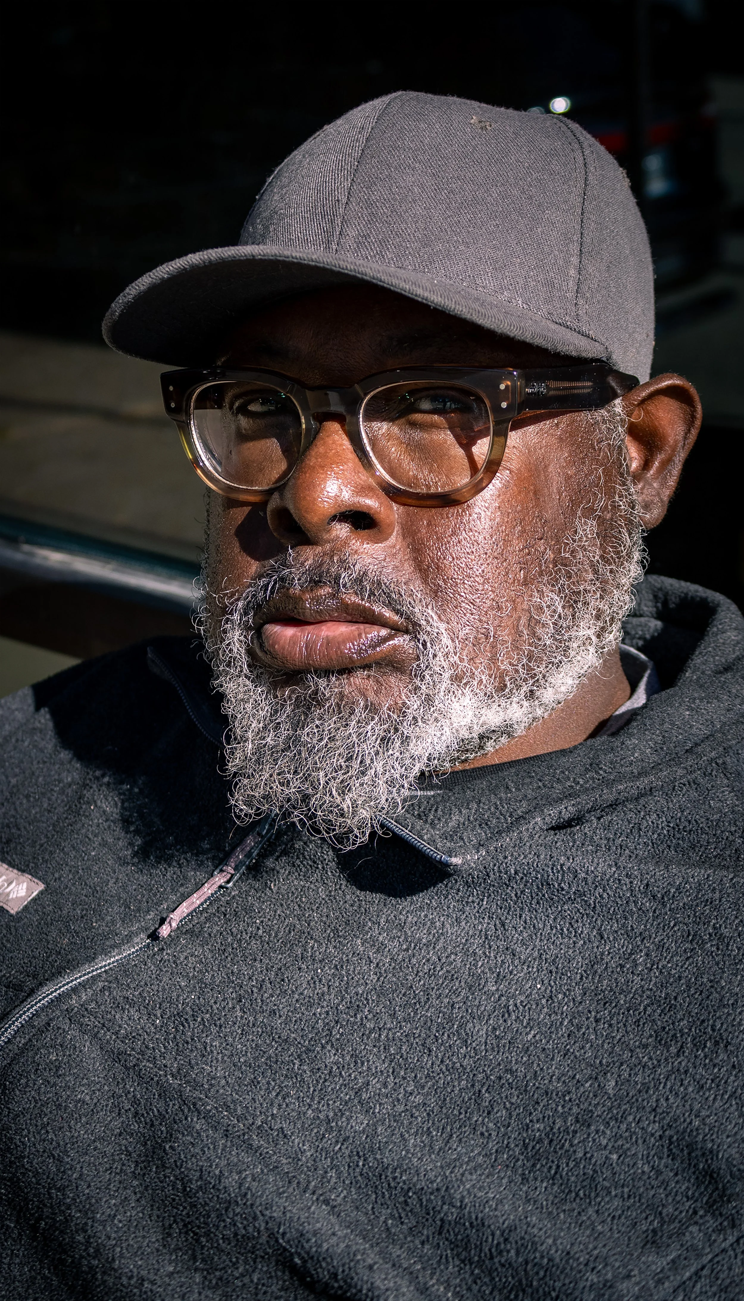 “Stoic Stranger”
This man wasn’t a man of many words. He was getting some sun outside of the Richford Arms Apartments and allowed me to photograph him with a simple head nod. When I wished him goodbye, I received another nod of the head as a farewell