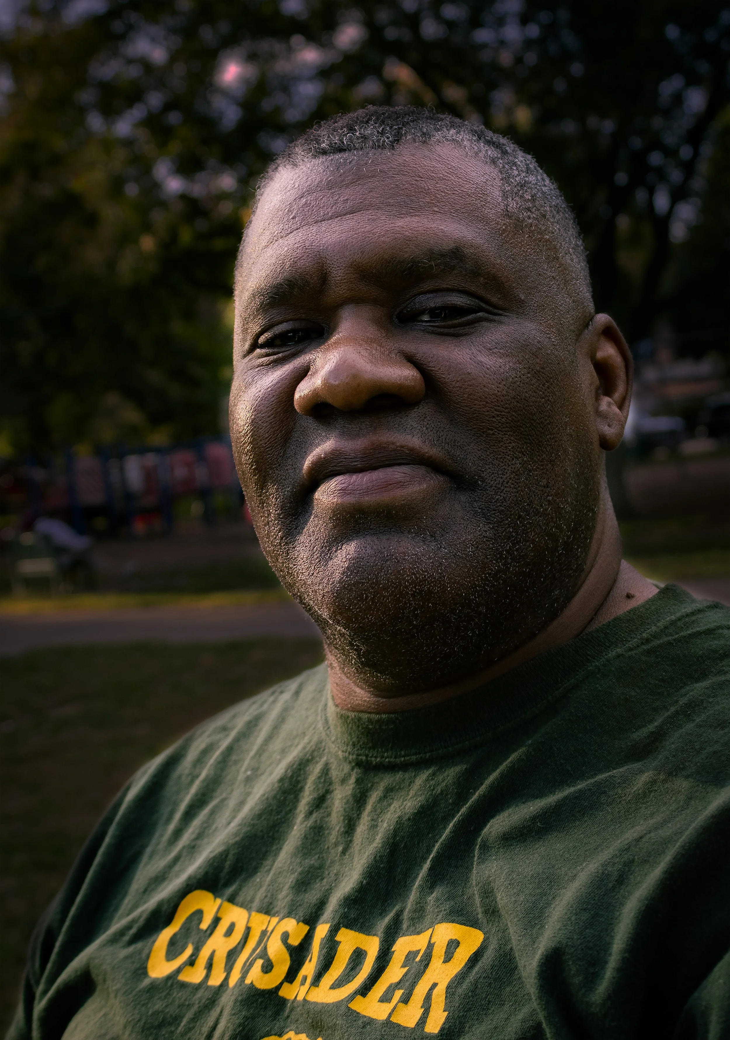 “Proud Father”
This father was sitting at a bench in Frontier Park, calmly watching his son participate in a track meet. I asked to photograph him because he looks so calm and happy watching his son. He gladly obliged.