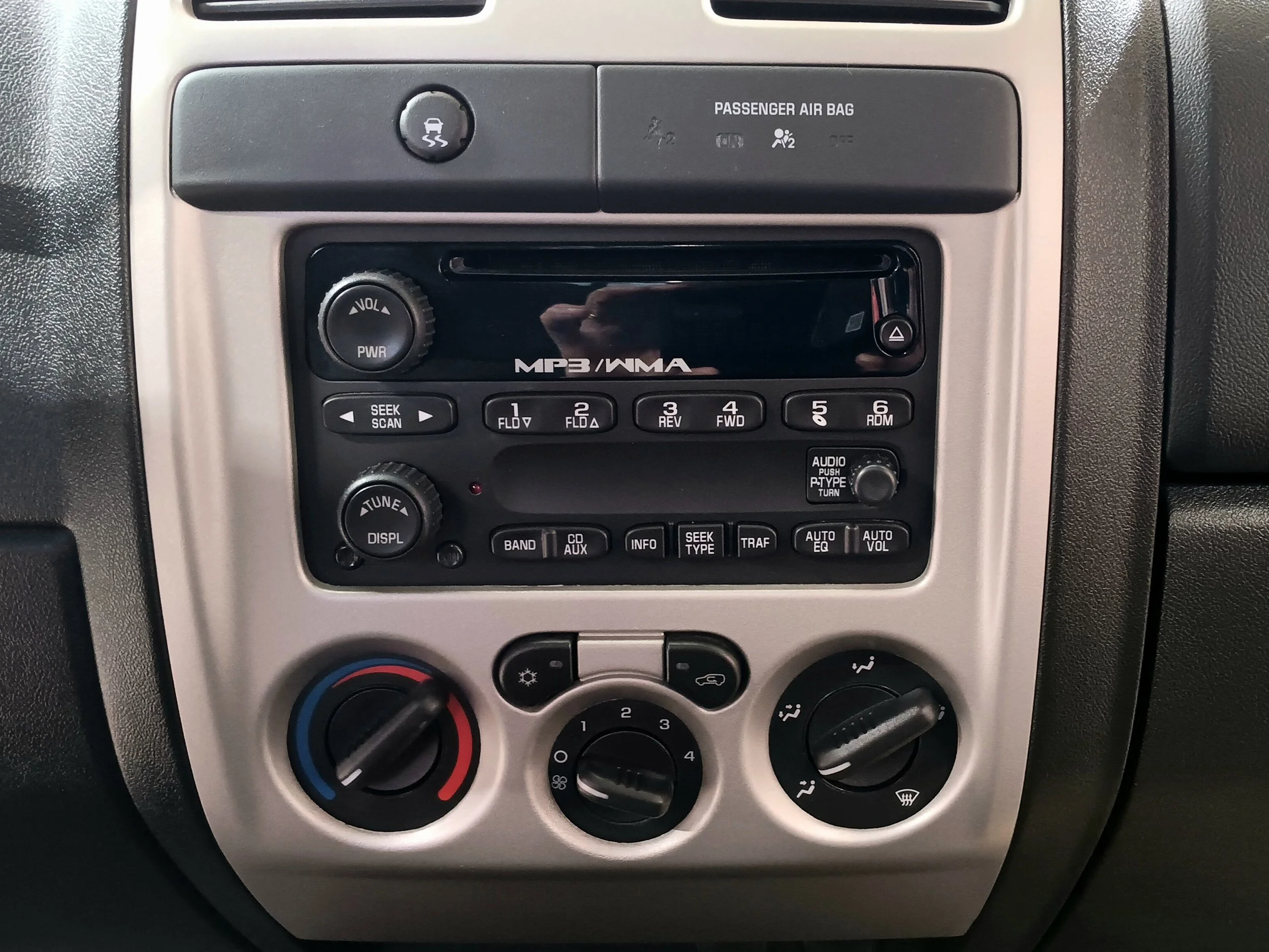 Dashboard of a vehicle showing climate controls, radio, and other vehicle controls.