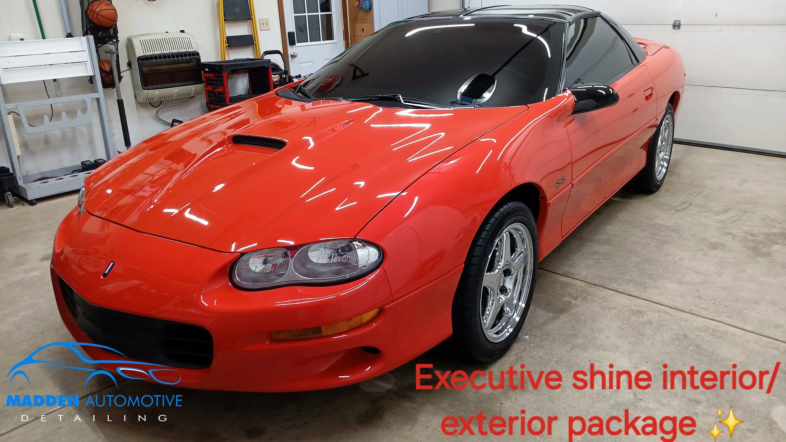 Orange Chevrolet Camaro SS with black roof parked in garage, featuring glossy finish and chrome wheels, promoted for executive shine interior and exterior package.