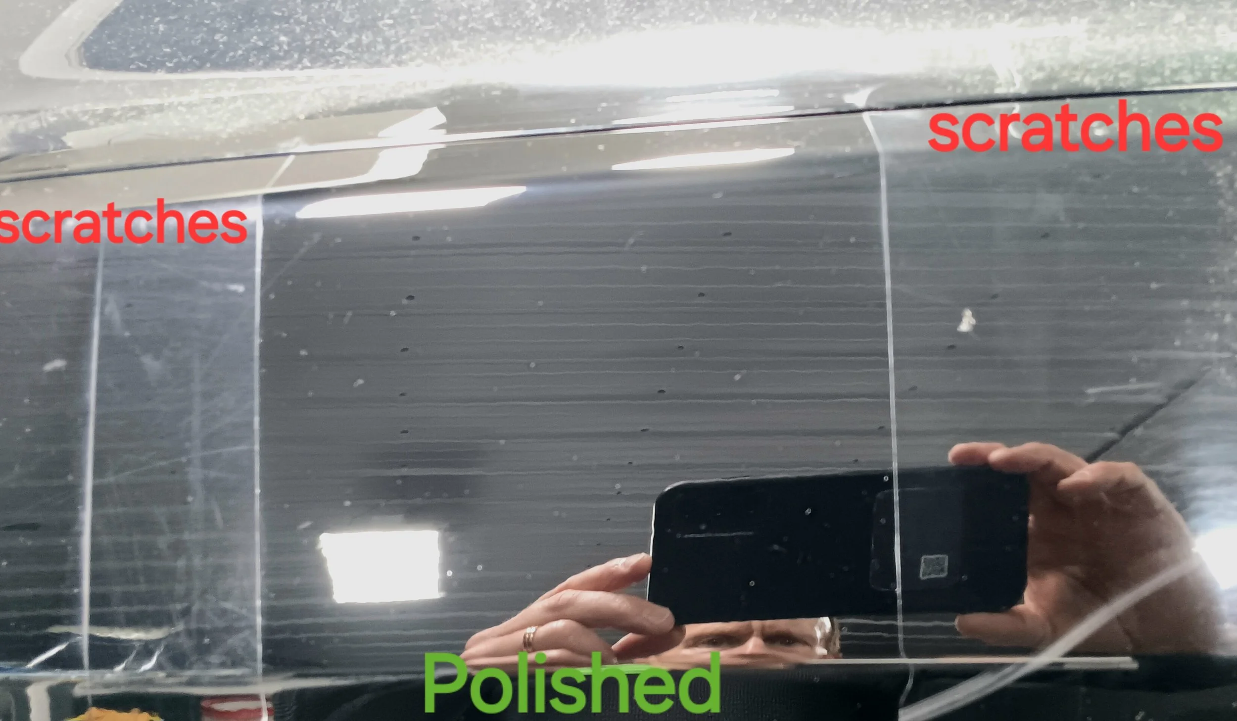 Close-up of a scratched and polished mirror showing reflection of a person holding a phone, with red text indicating scratches and green text indicating polished areas.