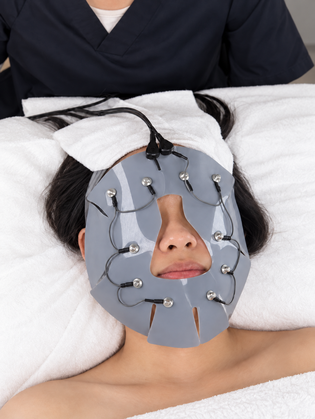 Person receiving a facial treatment with a face mask