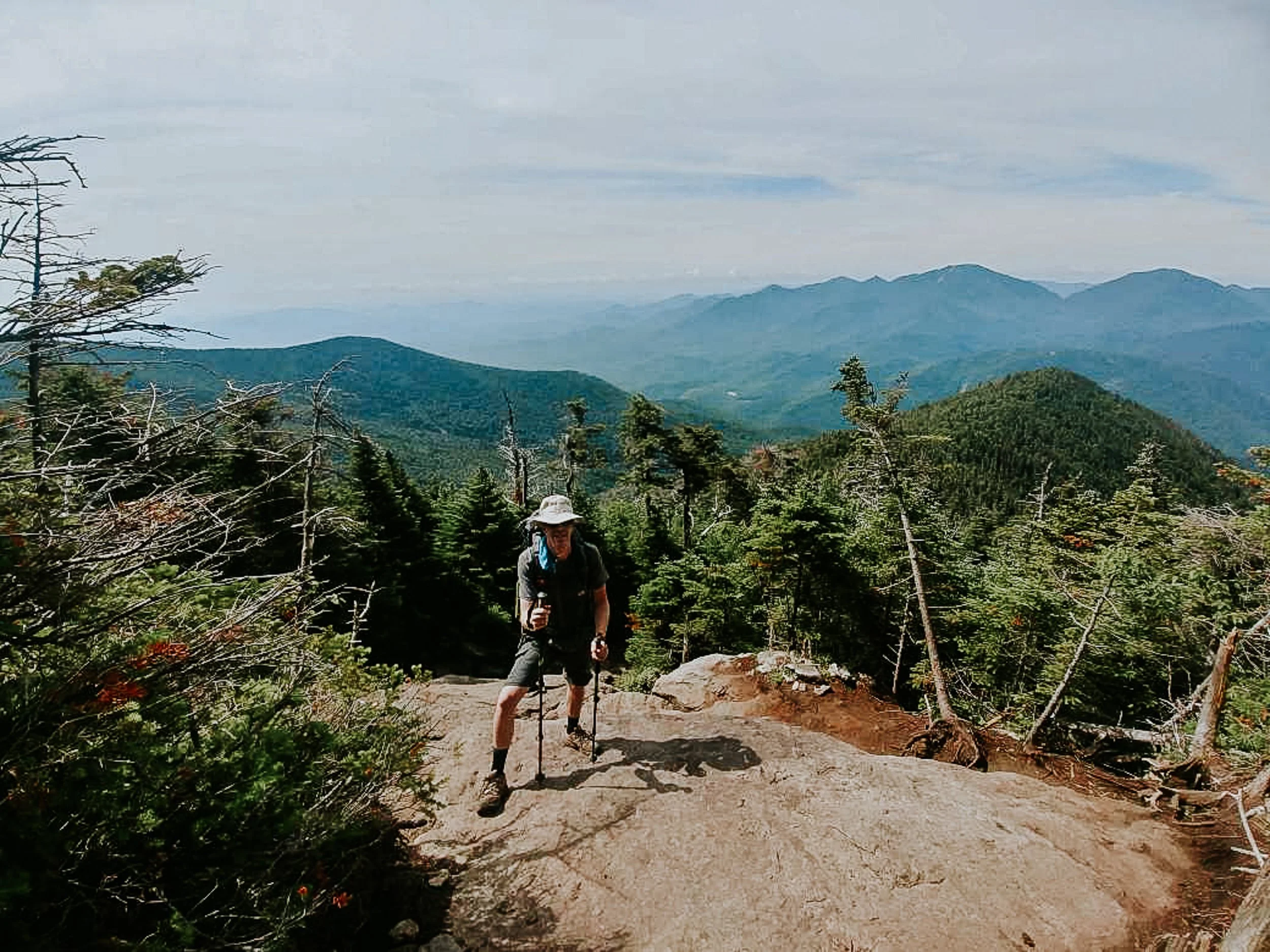 Man on a mountain just above the tree line in the Adiraondack Mountains.