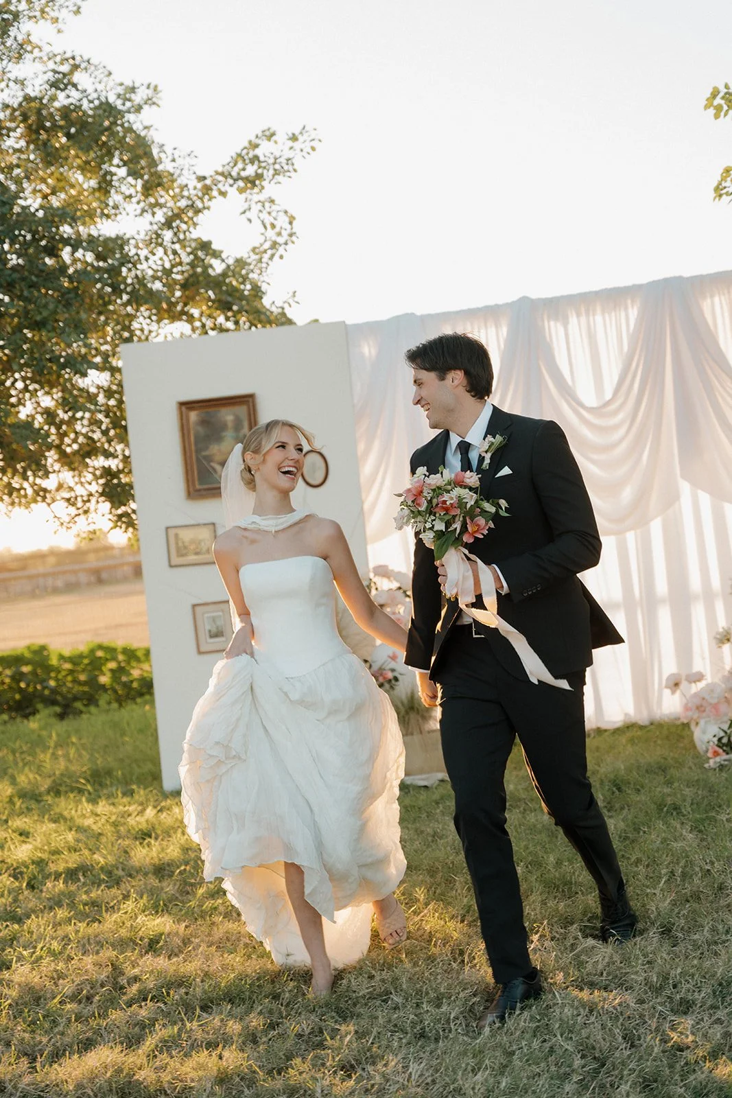 A bride and groom run in front of their ceremony arch setup, hosted by Made Event Co., a luxury wedding coordinator based in Arizona.