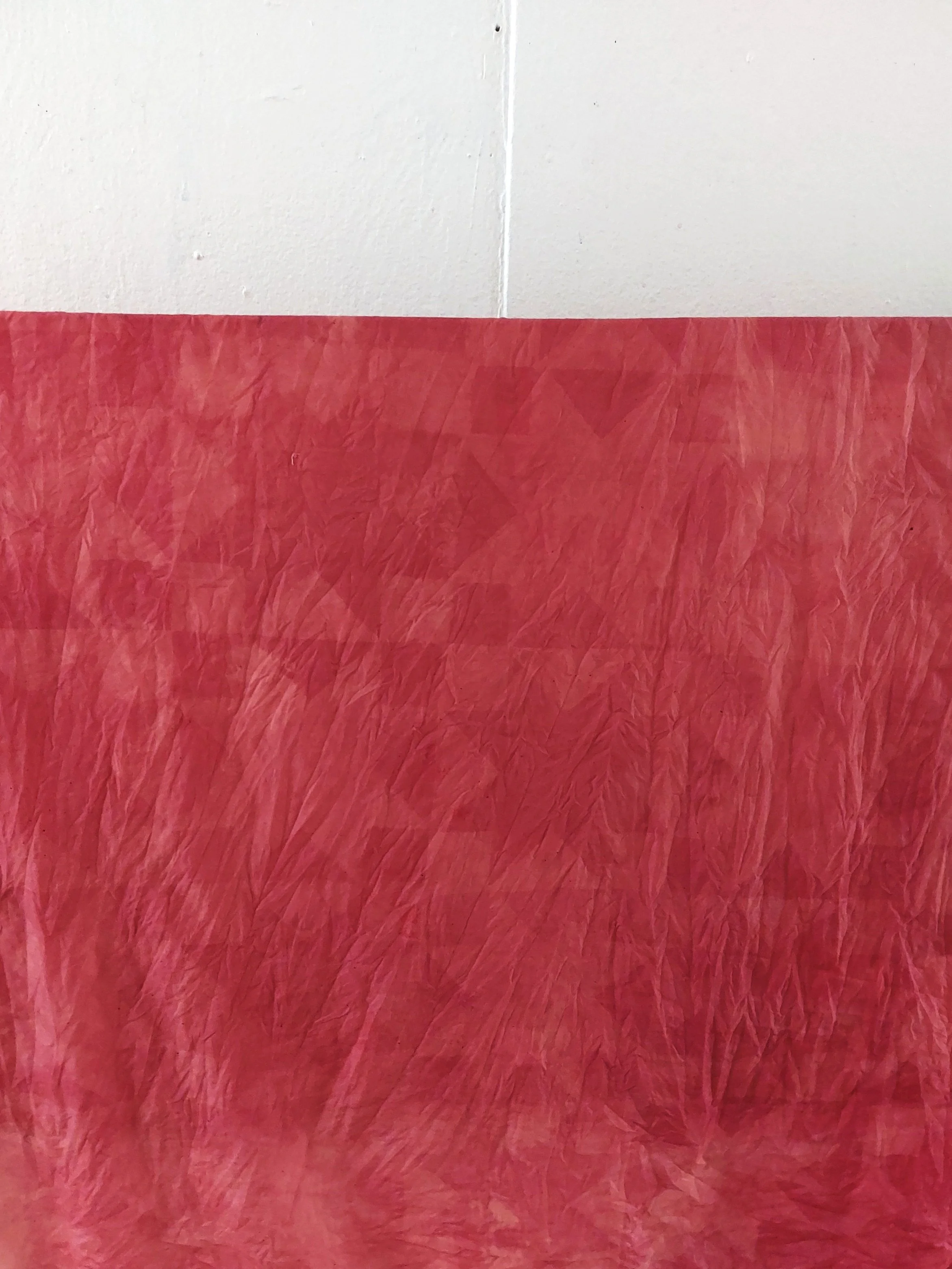 pink fabric, wet and wrinkled, printed with a quilt pattern in a lighter pink.