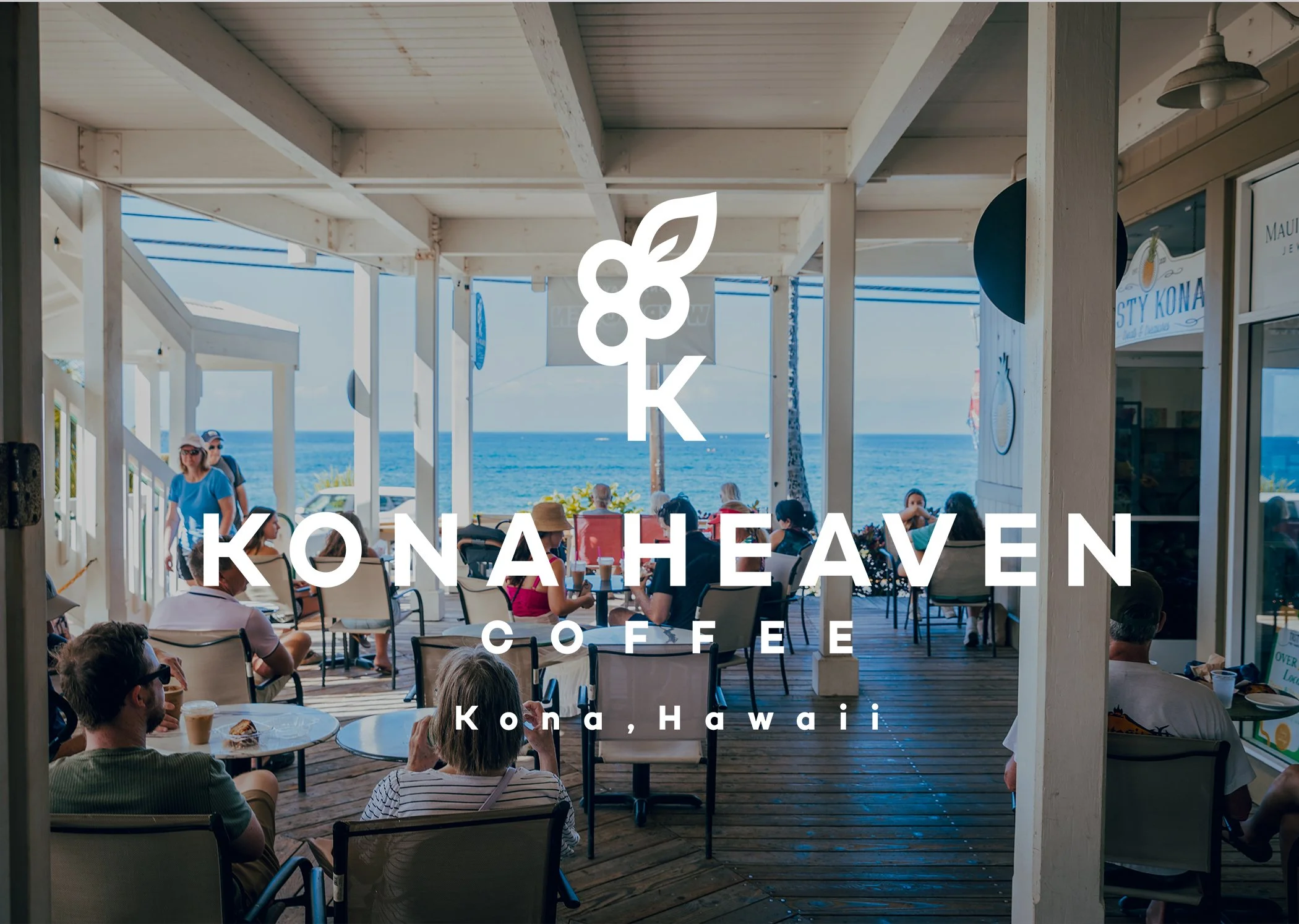 People dining on an outdoor deck overlooking the ocean at Kona Heaven Coffee in Kona, Hawaii.