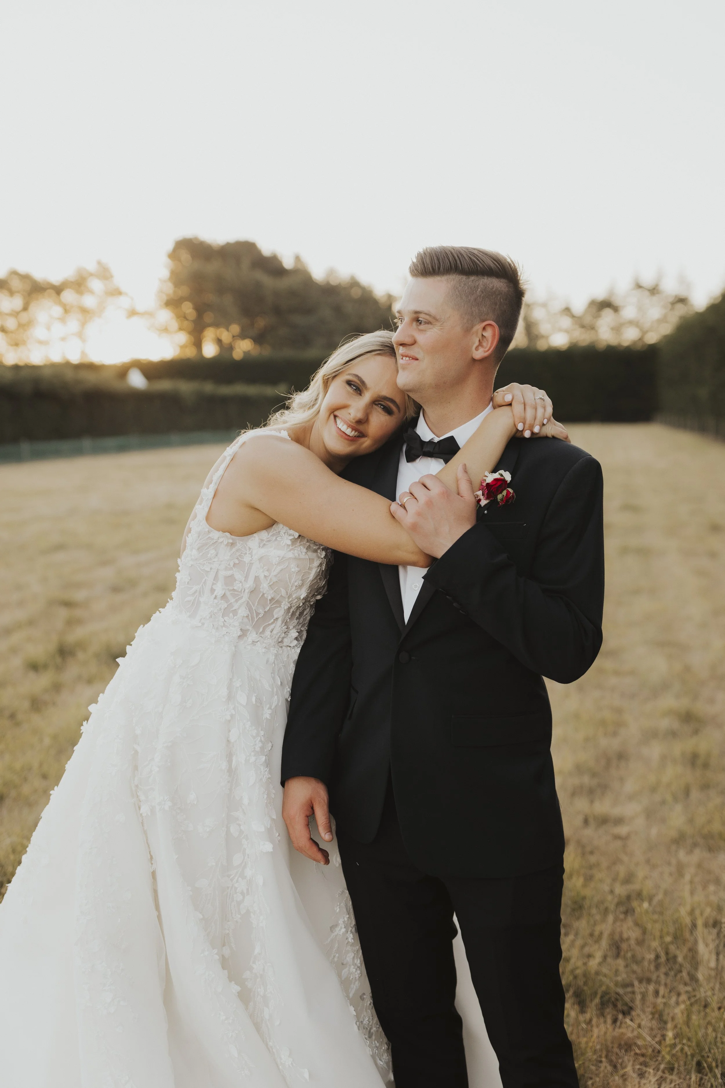Bride and groom embracing from Kylie and Nick's wedding at a golden field photographed by Sophie Isabella Photo