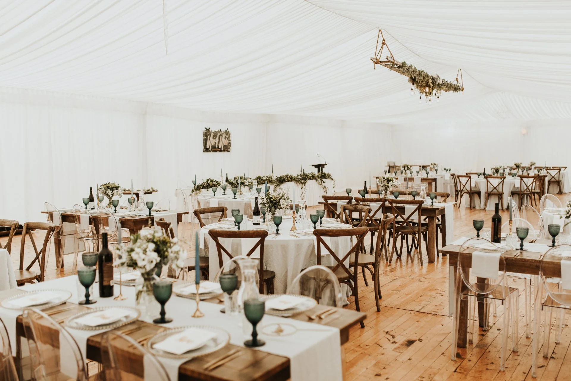 Wedding reception table setting with wooden floor in a marquee from Charlotte & Byron's wedding at Trott’s Garden photographed by Charlotte Sowman Photography