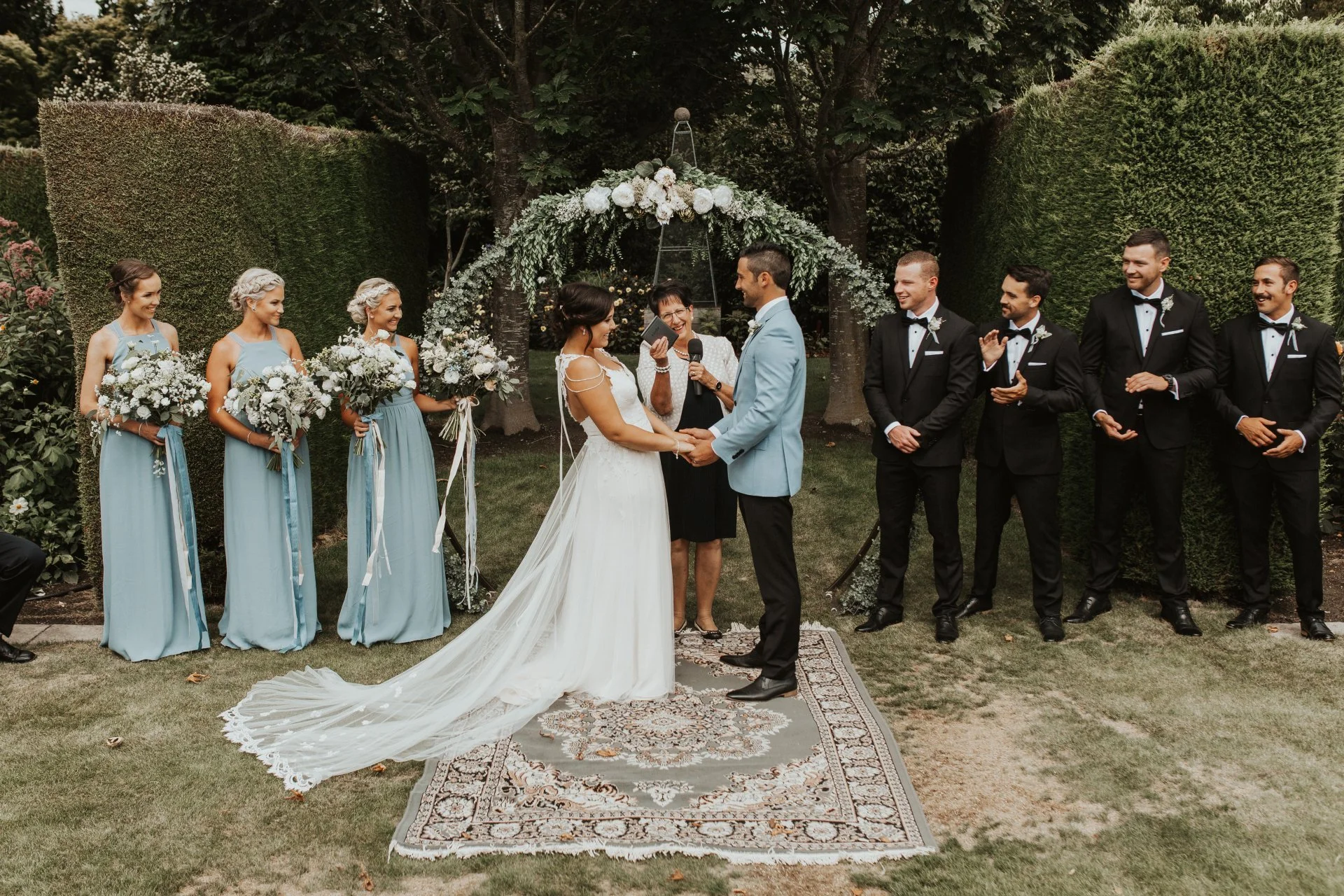 Bride and groom at the alter with ornate carpet and floral arch from Charlotte & Byron's wedding at Trott’s Garden photographed by Charlotte Sowman Photography