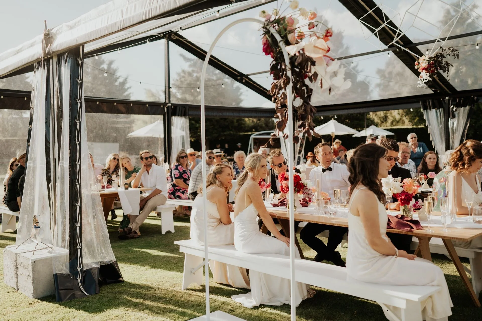 wedding reception in clear marquee with guests and bride looking on while speeches are made from Karin & Nic's wedding at Broadfield Gardens photographed by Sarah Clements Photography