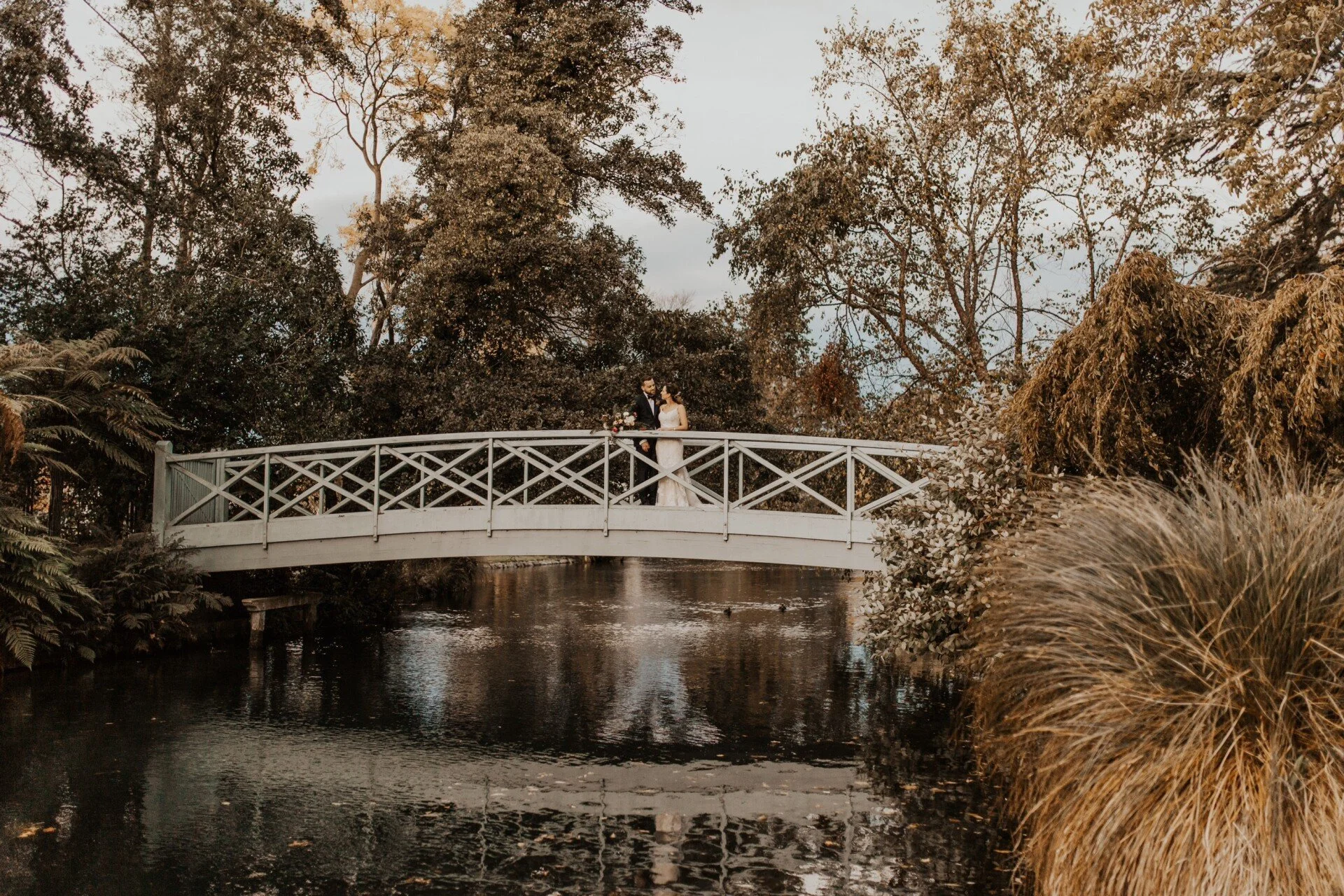 Bride and groom on bridge over Avon from Claire & Hamish's wedding at Mona Vale Homestead photographed by Susannah Blatchford Photography