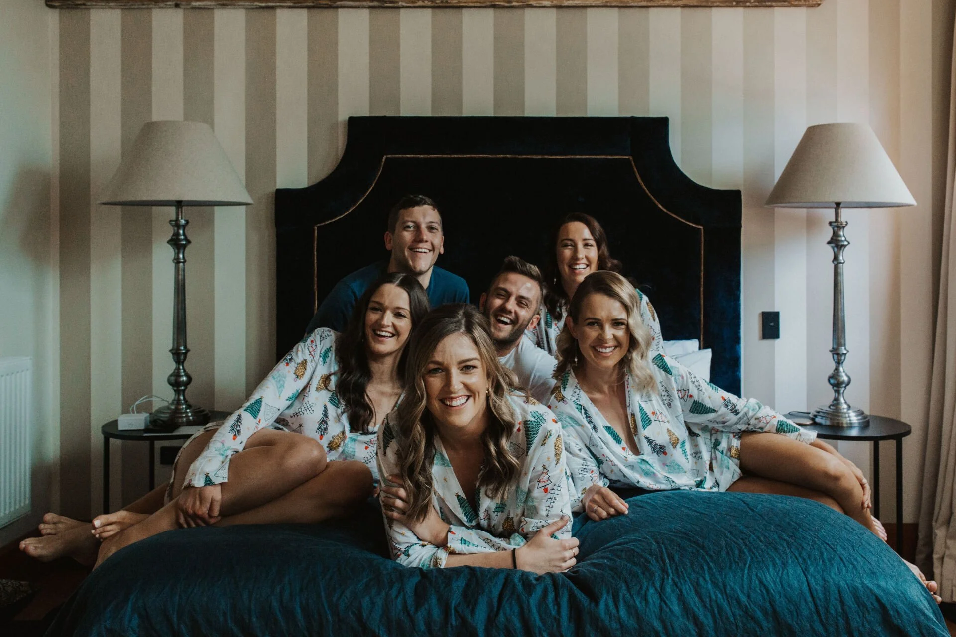 bridal party gathered on bed wearing matching pajamas from Jen & Lewis's wedding at Cossars Wineshed at Tai Tapu photographed by Sophie Isabella Photo