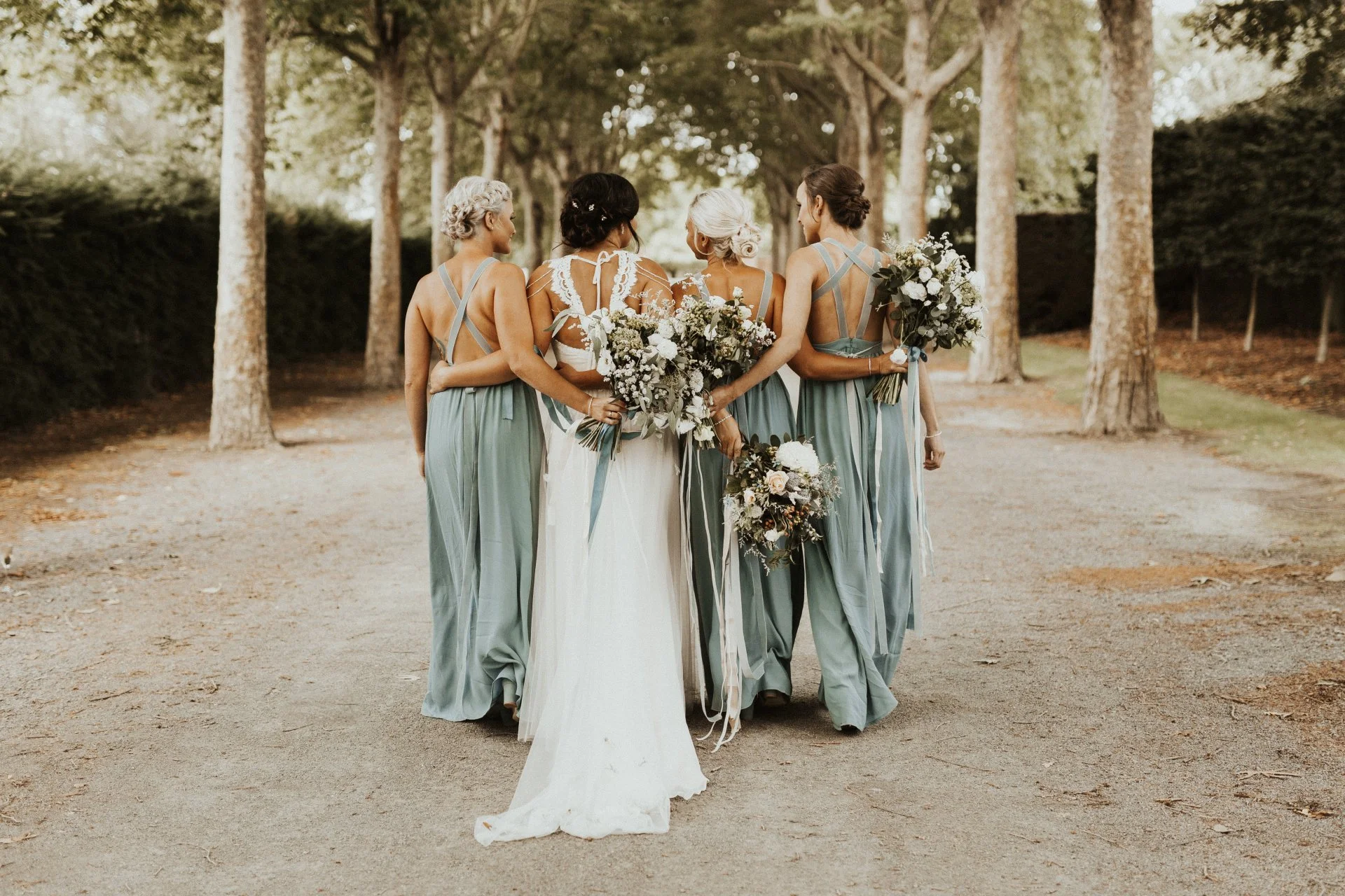 bridal party walking down tree lined lane from Charlotte & Byron's wedding at Trott’s Garden photographed by Charlotte Sowman Photography