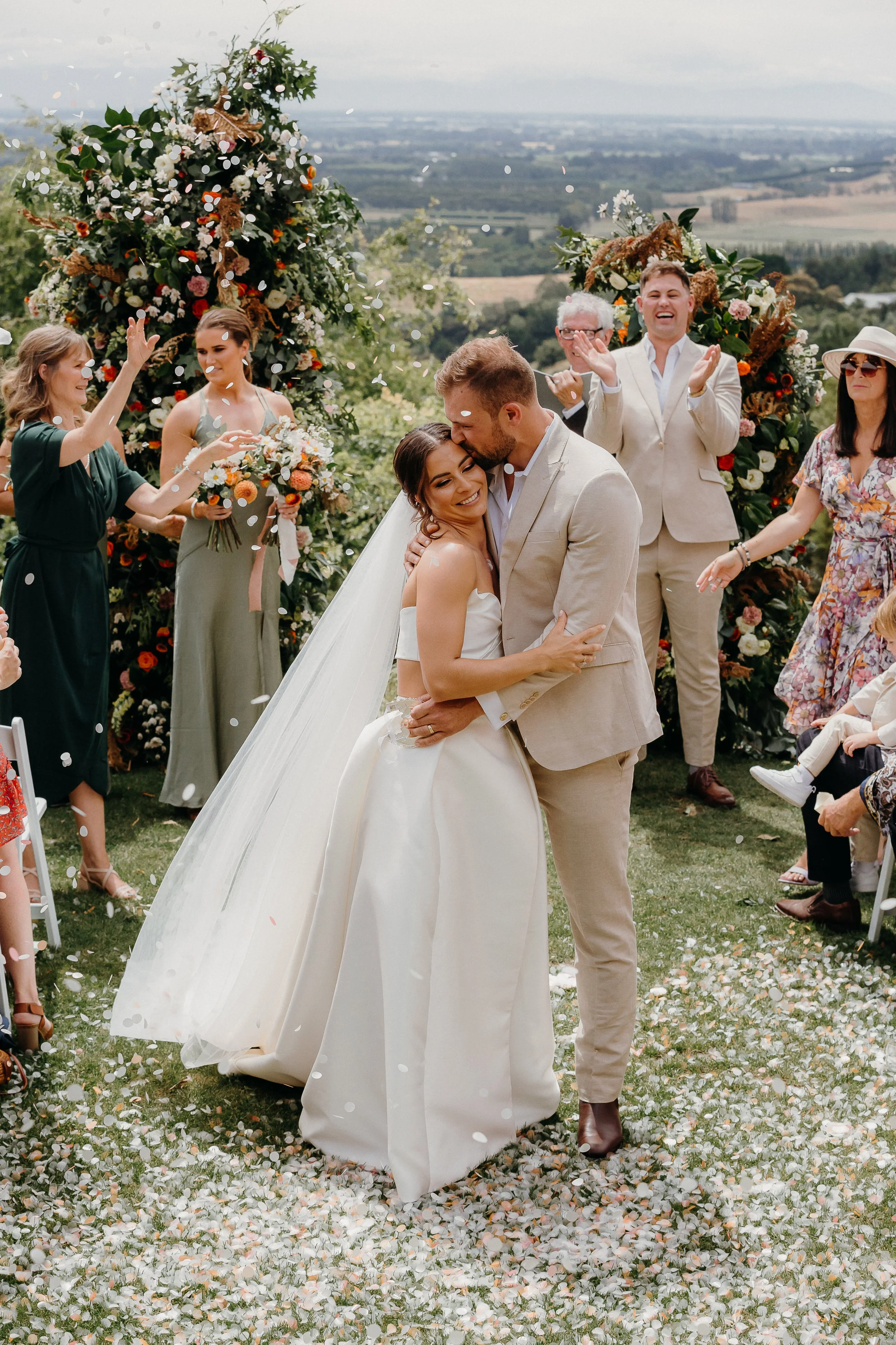 Bride and groom with confetti from Michelle and Sam's wedding at Waipuna Estate photographed by Koru Photography