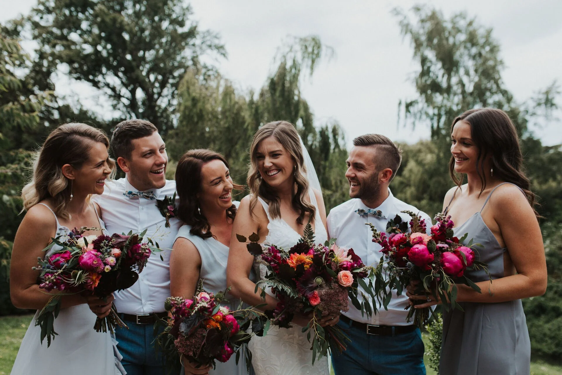 bridal party holding dark pink bouquets from Jen & Lewis's wedding at Cossars Wineshed at Tai Tapu photographed by Sophie Isabella Photo