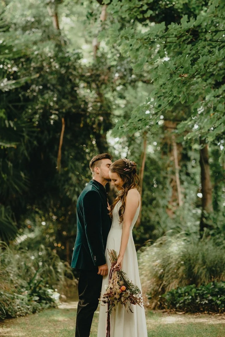 Bride and groom standing in front of trees from Hannah & Jesse's wedding at Stonebridge photographed by Ashlee Adam Photography