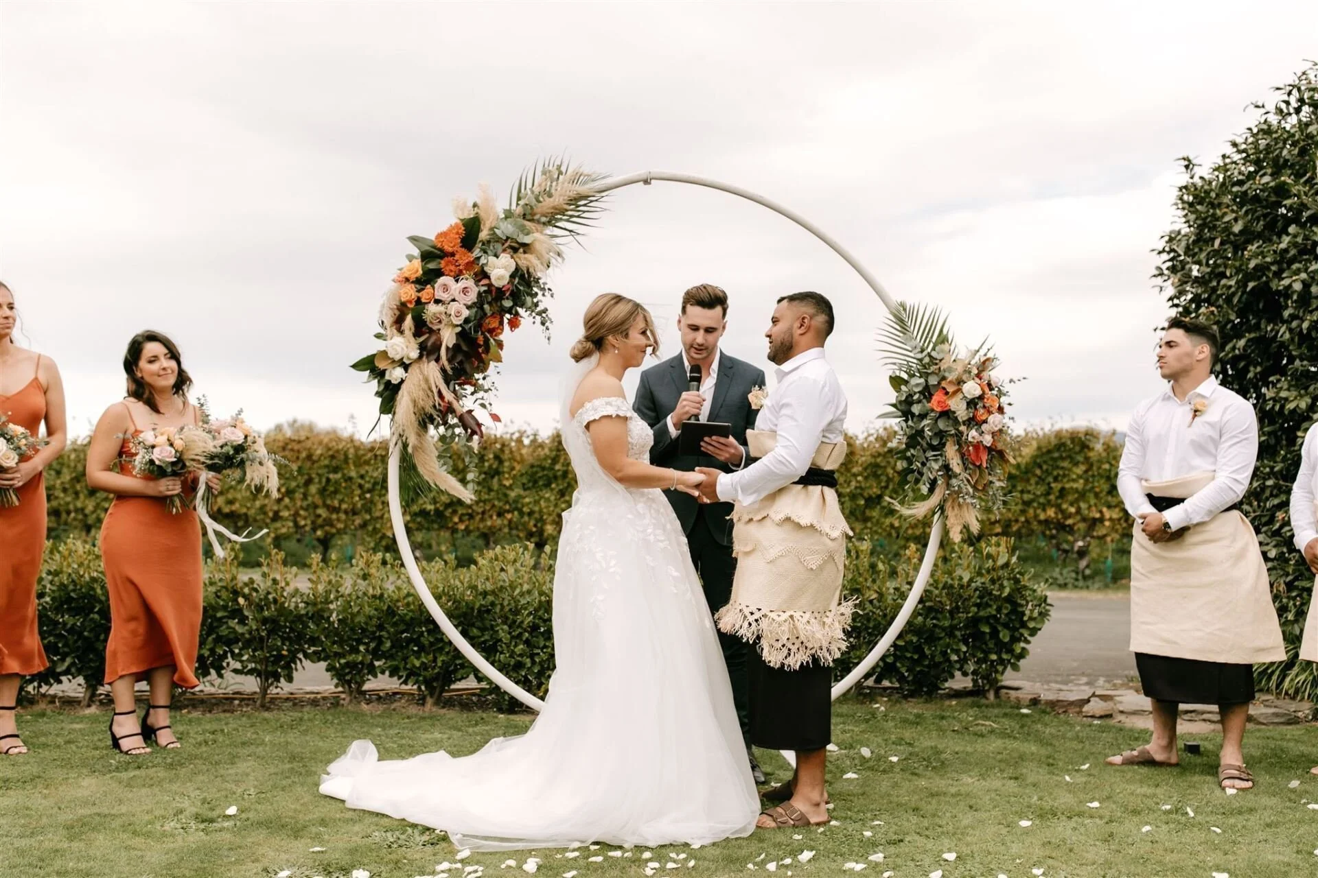 Bride and groom at the altar in front of floral ring from Hannah & Jarel's wedding at Seifried Estate photographed by Renee Edwards Photography