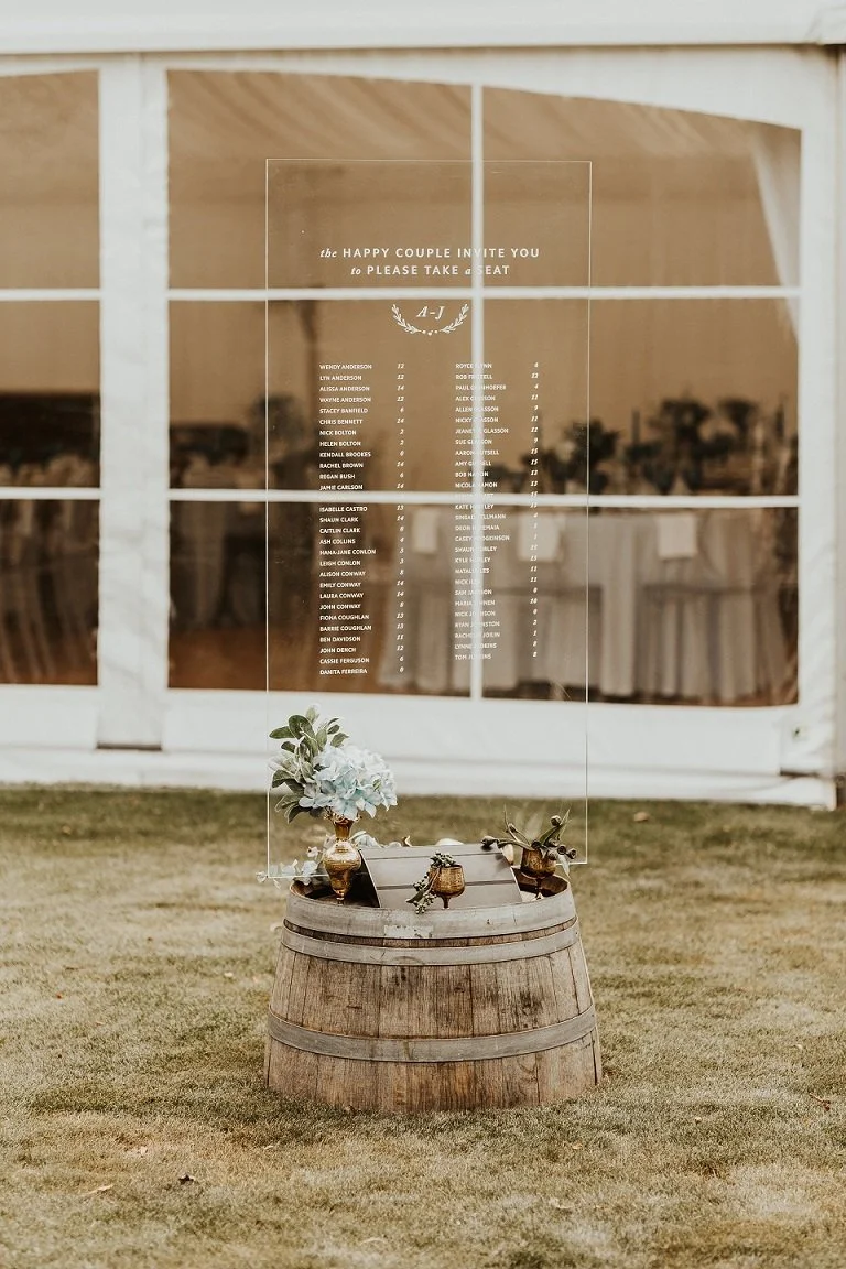Clear perspex wedding seating chart outside a marquee from Charlotte & Byron's wedding at Trott’s Garden photographed by Charlotte Sowman Photography