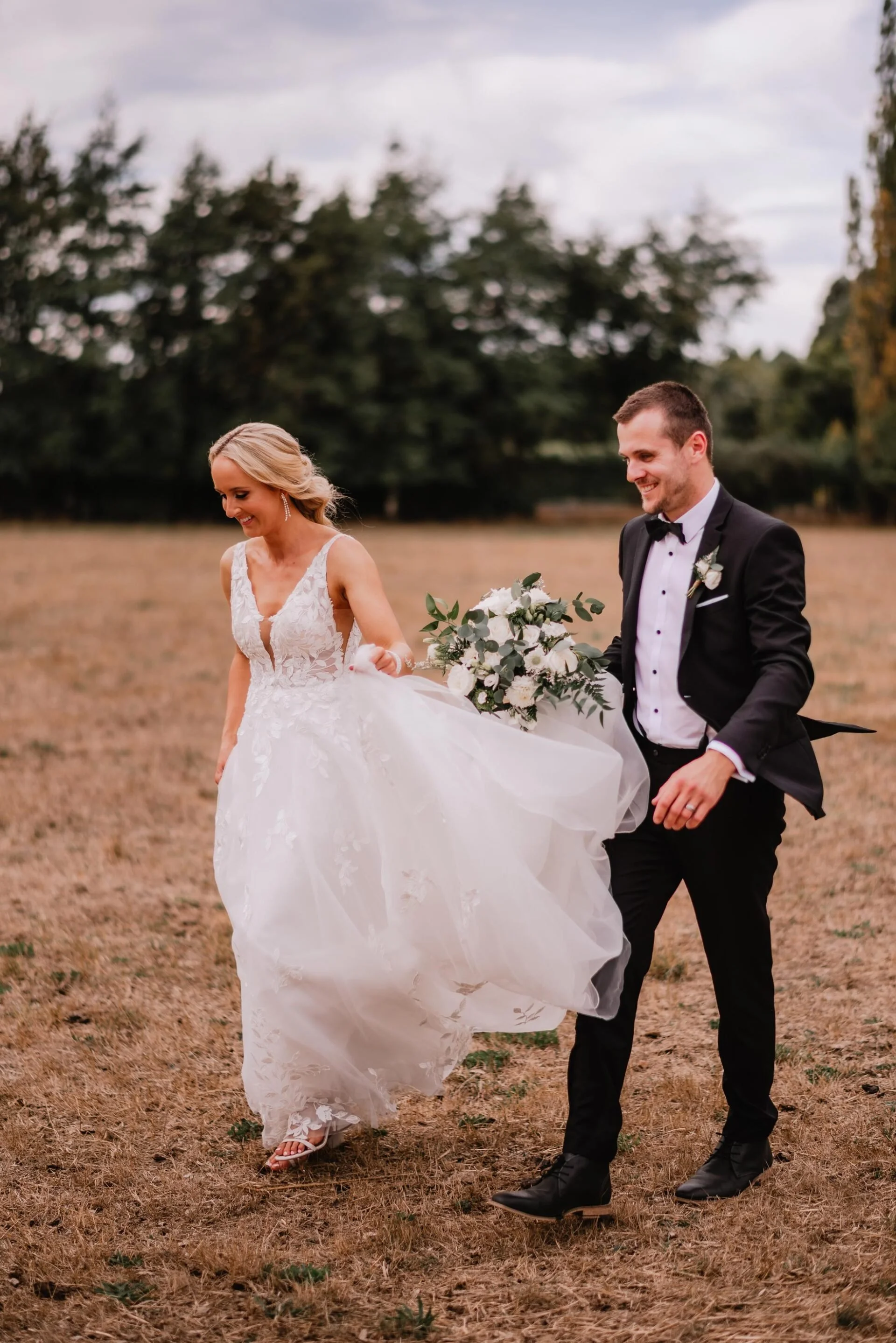 Bride and groom in a golden field with green and white bouquet from Cushla & Harry's wedding at Pemberton Gardens photographed by Joseph O’Sullivan Photography
