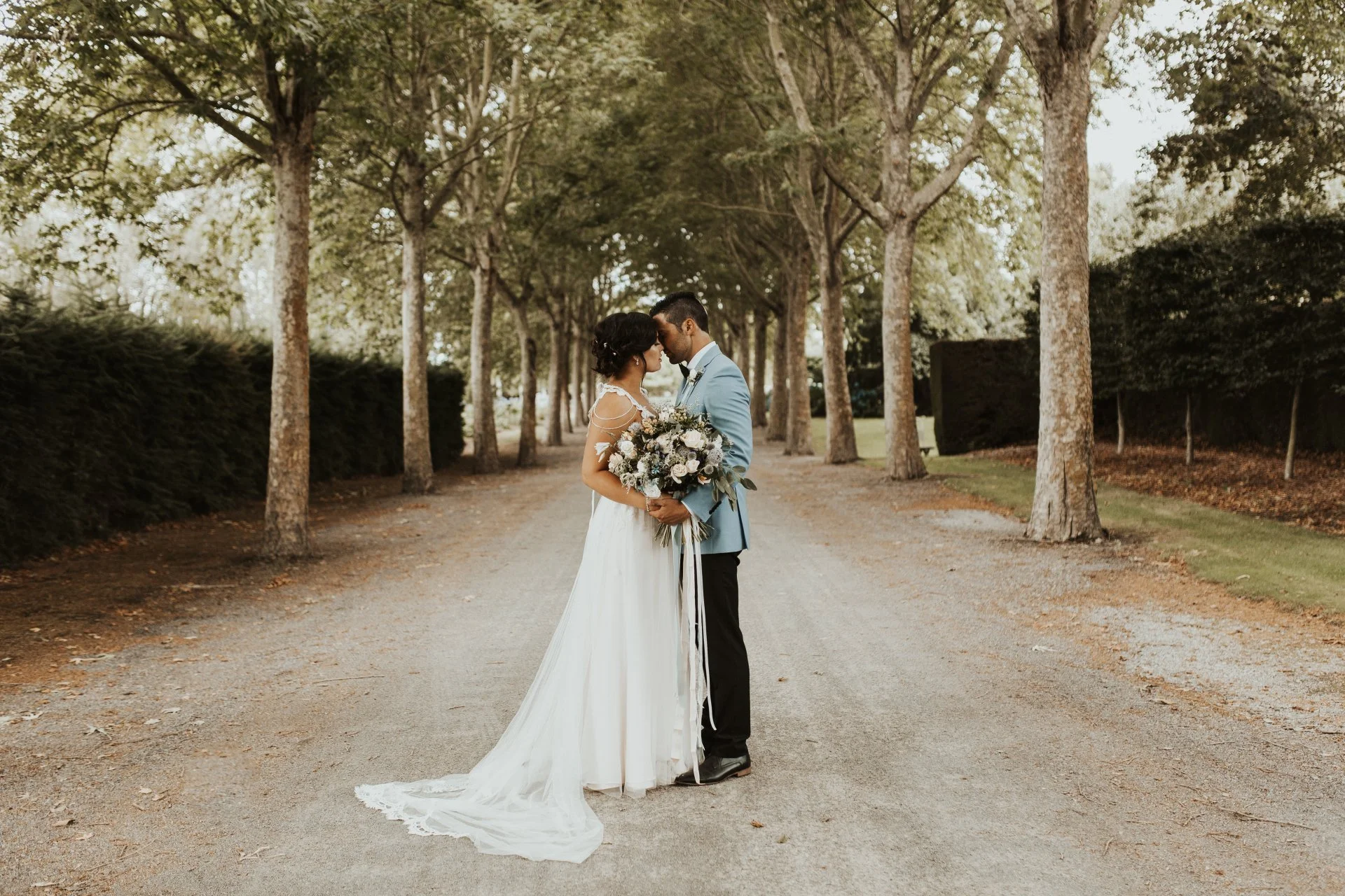 bride and groom kissing in tree lined lane from Charlotte & Byron's wedding at Trott’s Garden photographed by Charlotte Sowman Photography