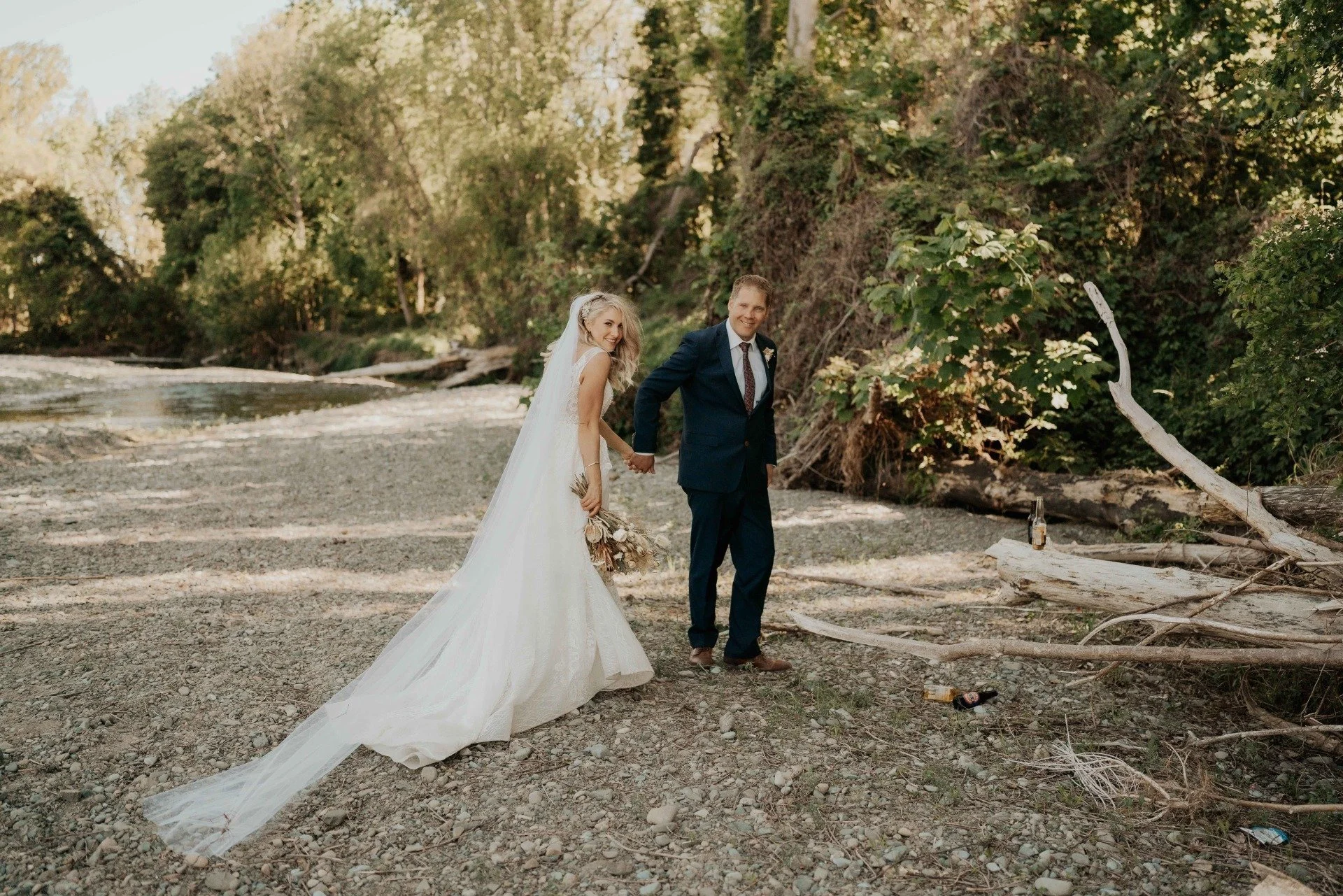 Bride and groom on riverbank from Kirsty & Cameron's wedding at Stonebridge photographed by Sarah Clements Photography