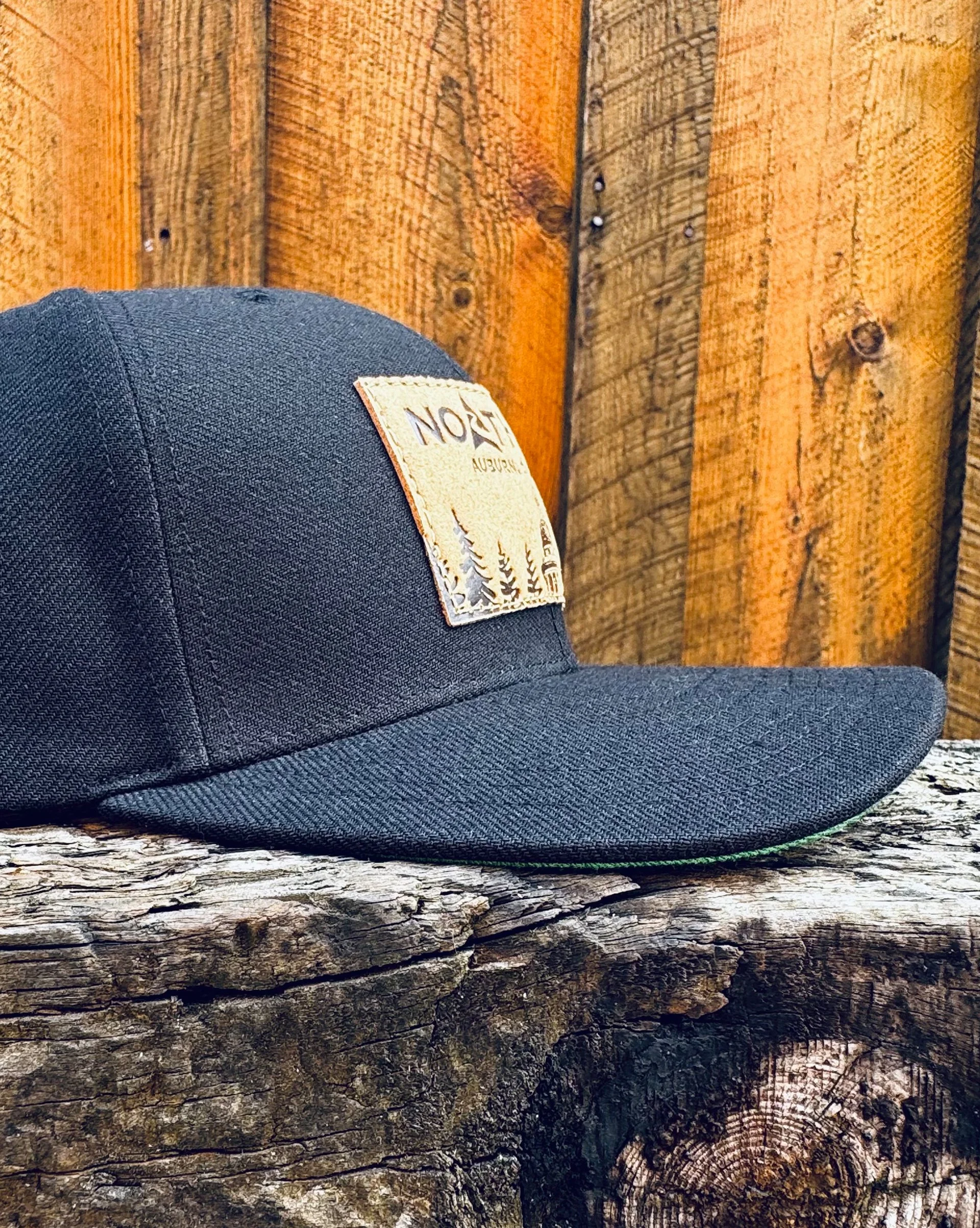 CourthouseLeatherPatchHat-BlackProfile-WoodBG.jpg
