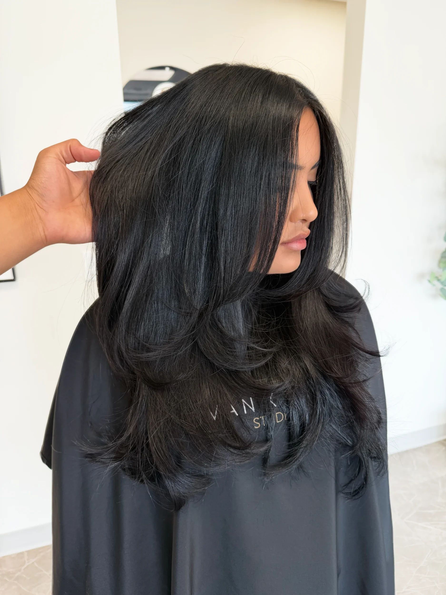 Butterfly layers haircut on long dark hair with voluminous face-framing layers by Ivan at Ivan X Hair salon in Kennewick, WA