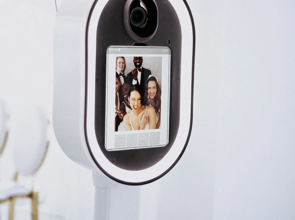 A device with a camera and screen showing a group of five diverse, smiling people taking a selfie.