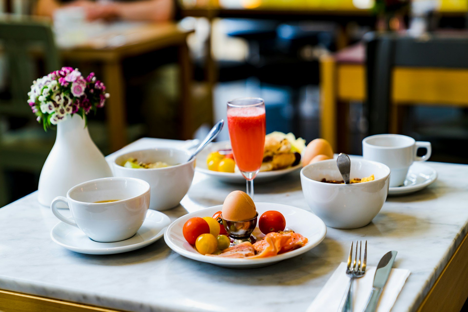 Petit-déjeuner équilibré avec œufs, saumon, fruits, légumes, jus de fruits et café, illustrant une alimentation adaptée aux troubles digestifs.