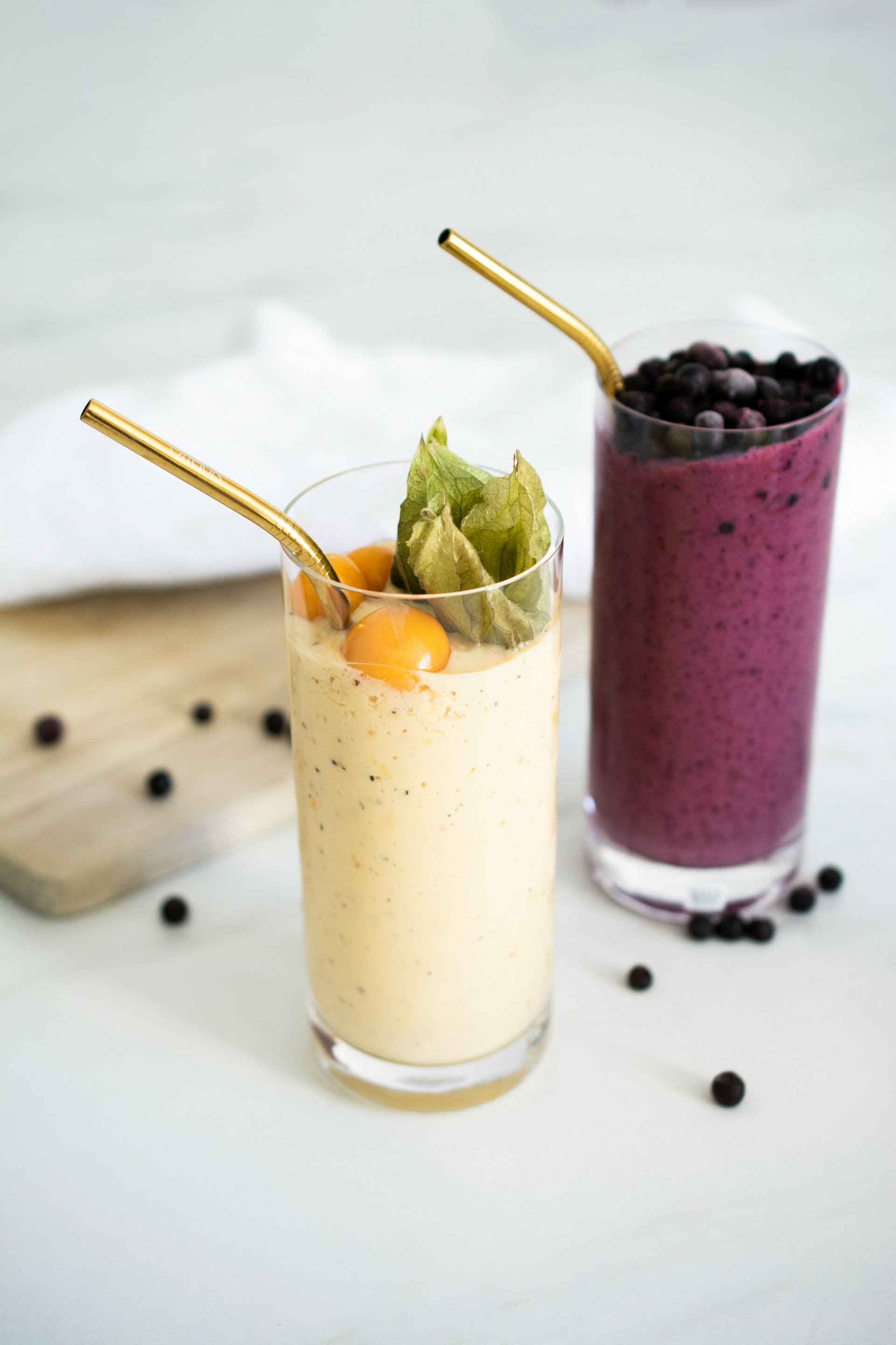 Deux smoothies colorés, l'un jaune au physalis et l'autre violet aux myrtilles, adaptés aux petites prises alimentaires pendant une chimiothérapie