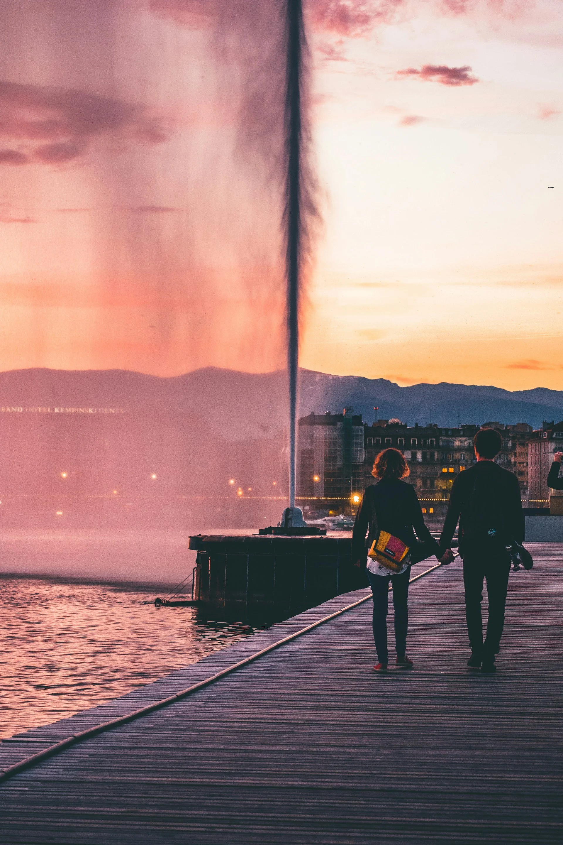 Couple marchant le long du jet d'eau à Genève, illustrant un mode de vie sain et actif après l'arrêt du tabac.