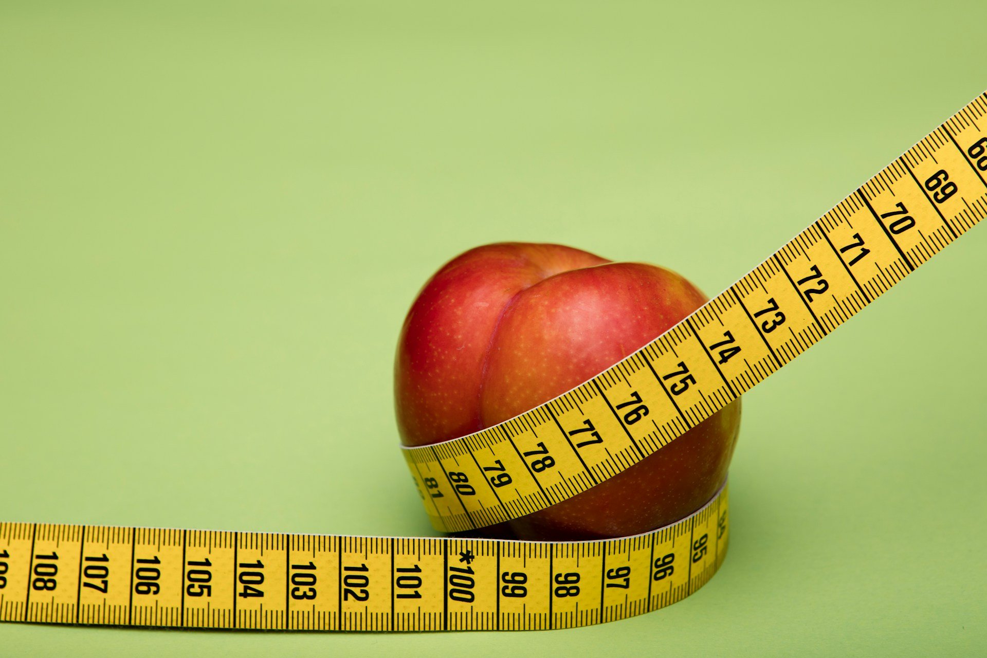 Pomme entouré d'un mètre de couturière  illustrant le rééquilibrage alimentaire et la perte de poids durable à Genève