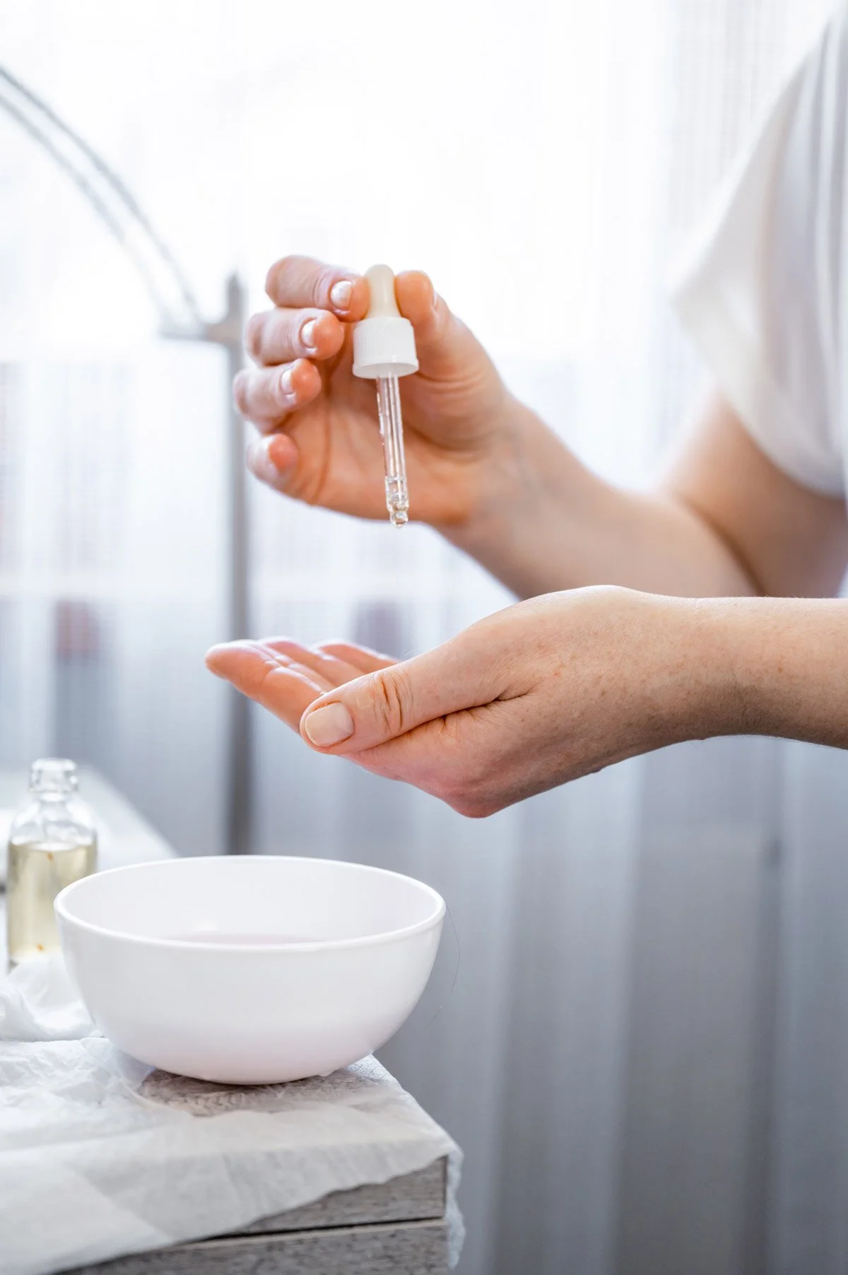 Person nutzt eine Pipette, um Flüssigkeit in eine Schüssel zu tropfen.