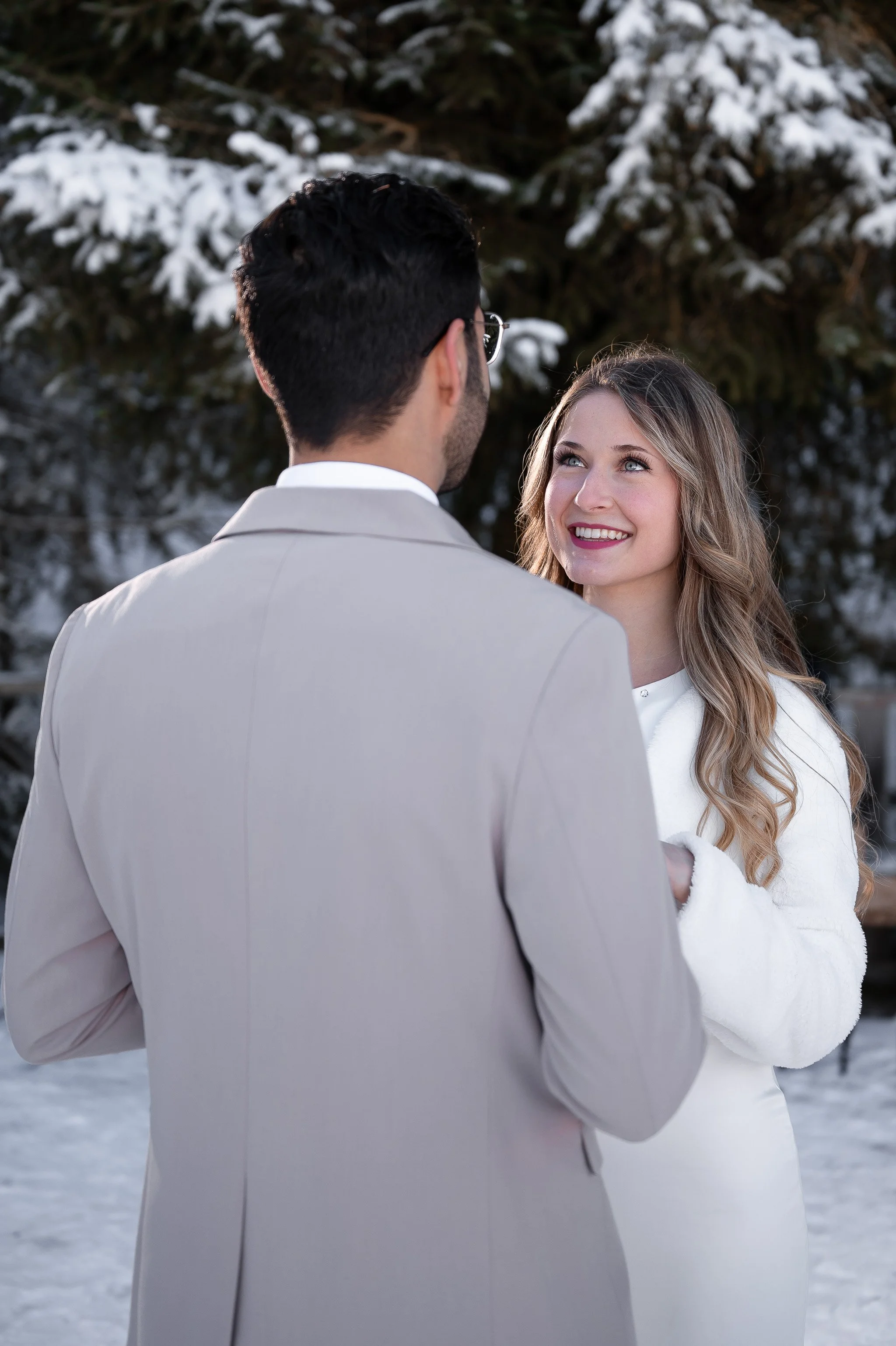 Ein Brautpaar steht sich im Schnee gegenüber.
