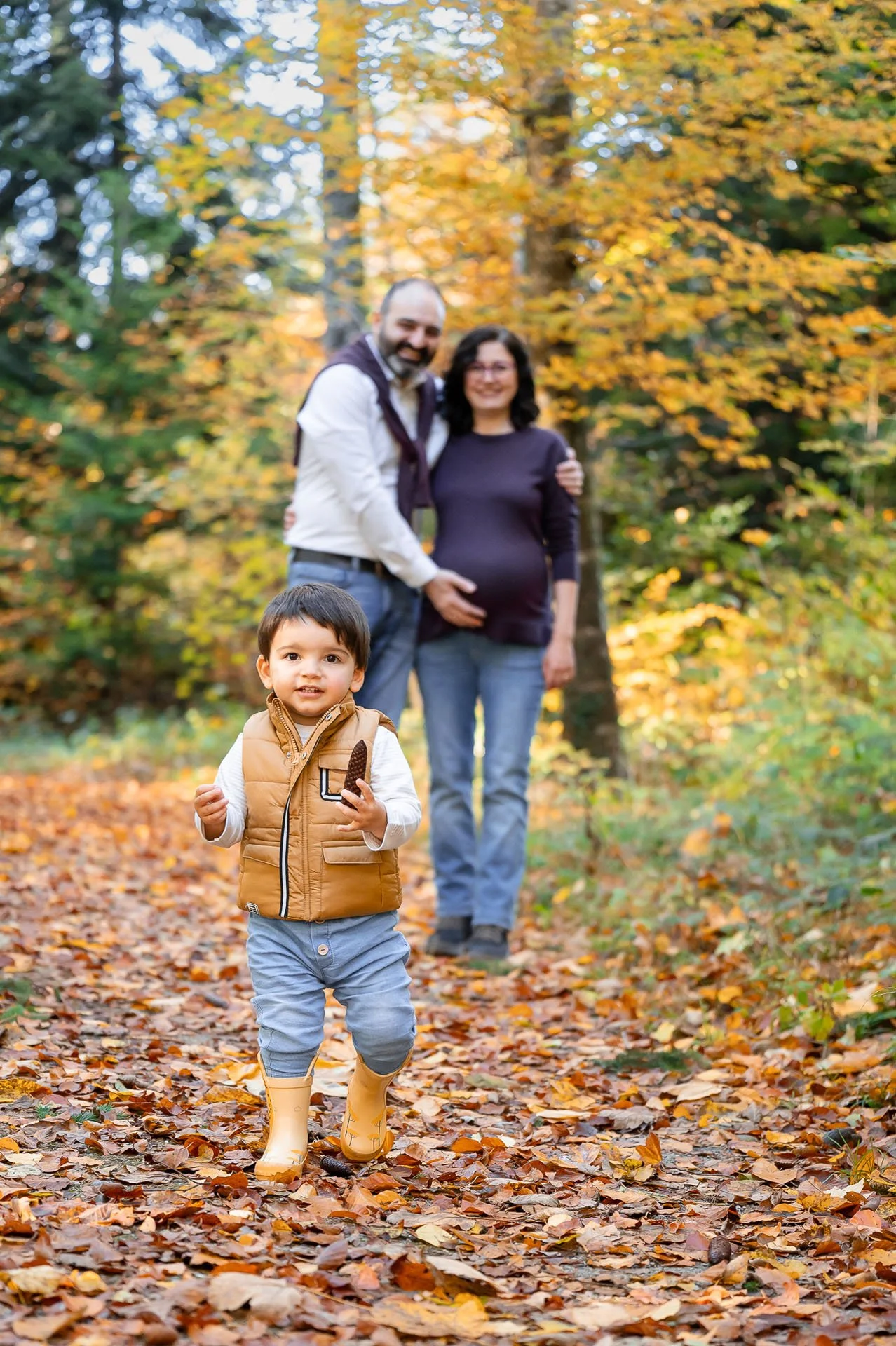 Familie mit Kind bei einem Herbstshooting im Wald.