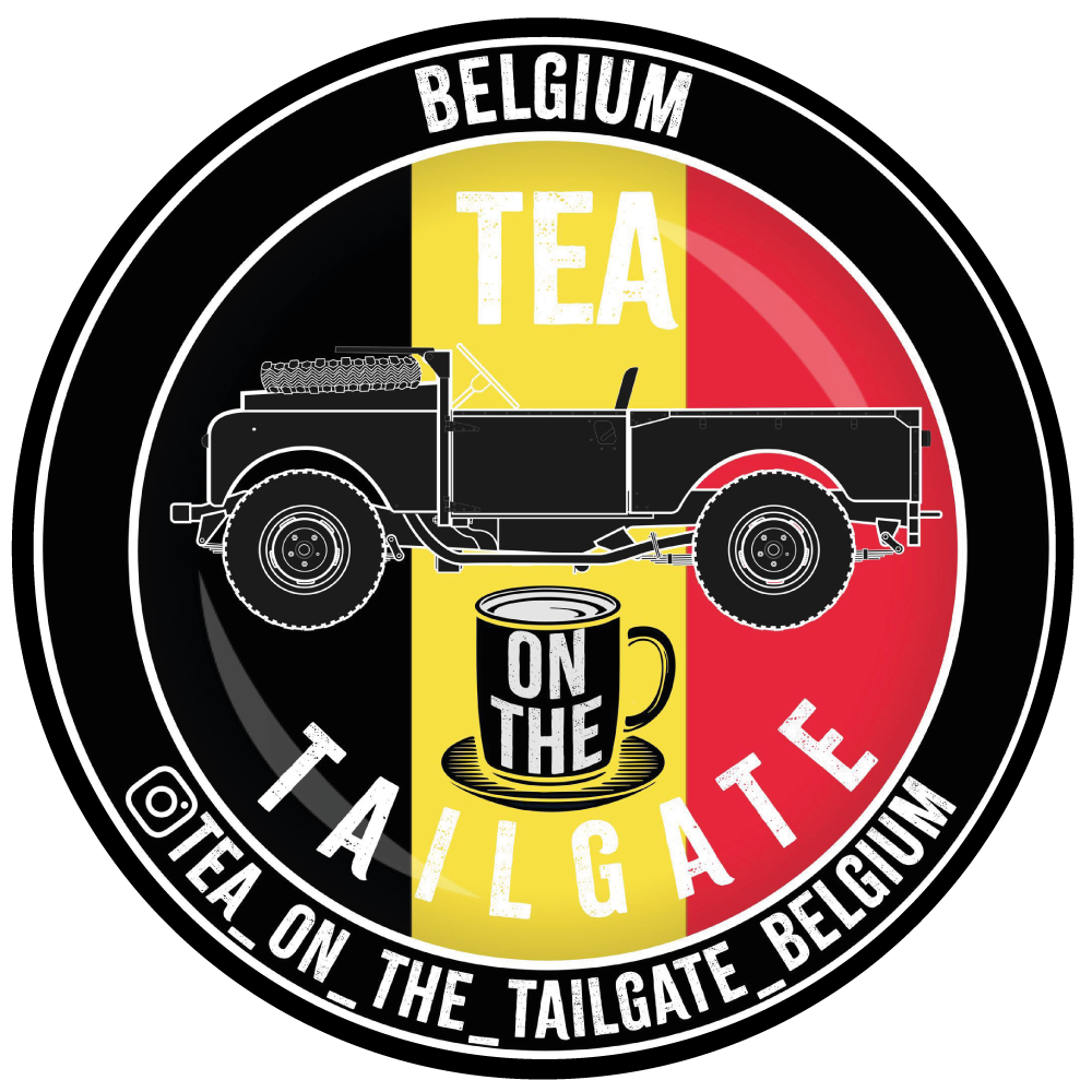 Een badge met het Belgische vlagontwerp, een silhouet van een auto, een kopje thee en de woorden 'Tea on the Tailgate Belgium'.