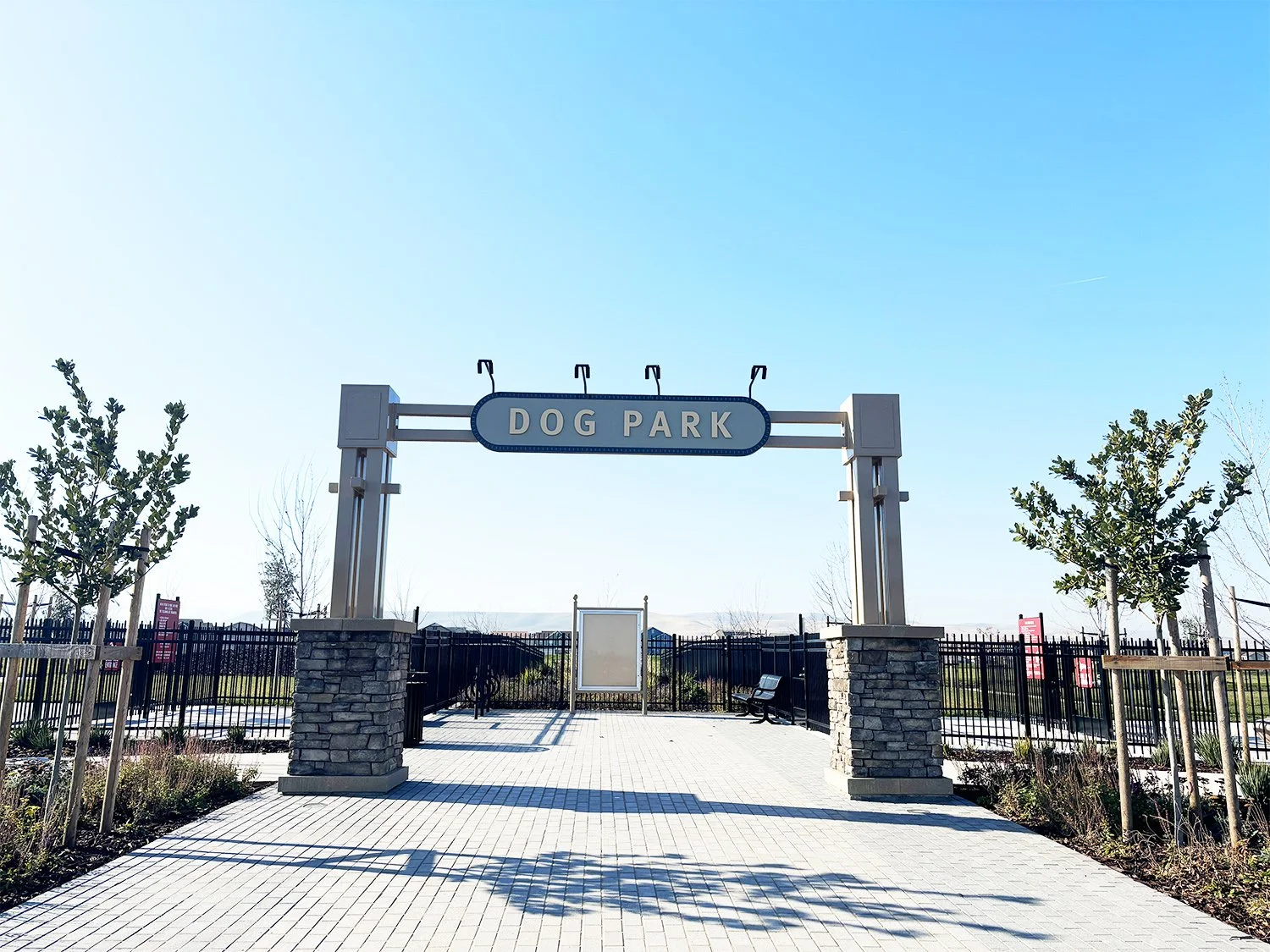 A custom gateway sign marks the entrance to the dog park.