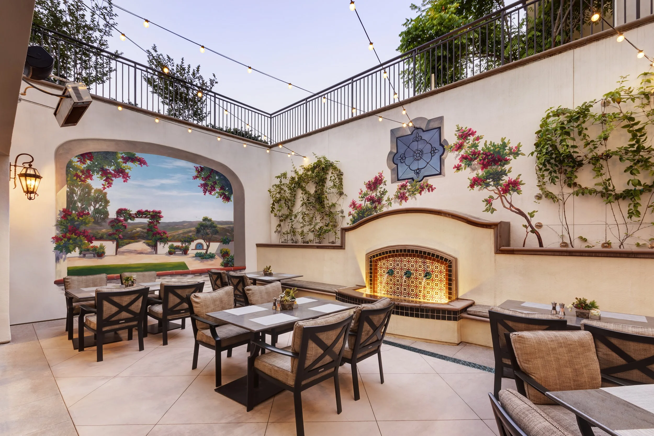 Mediterranean-inspired upper and lower terrace with dining area and water feature