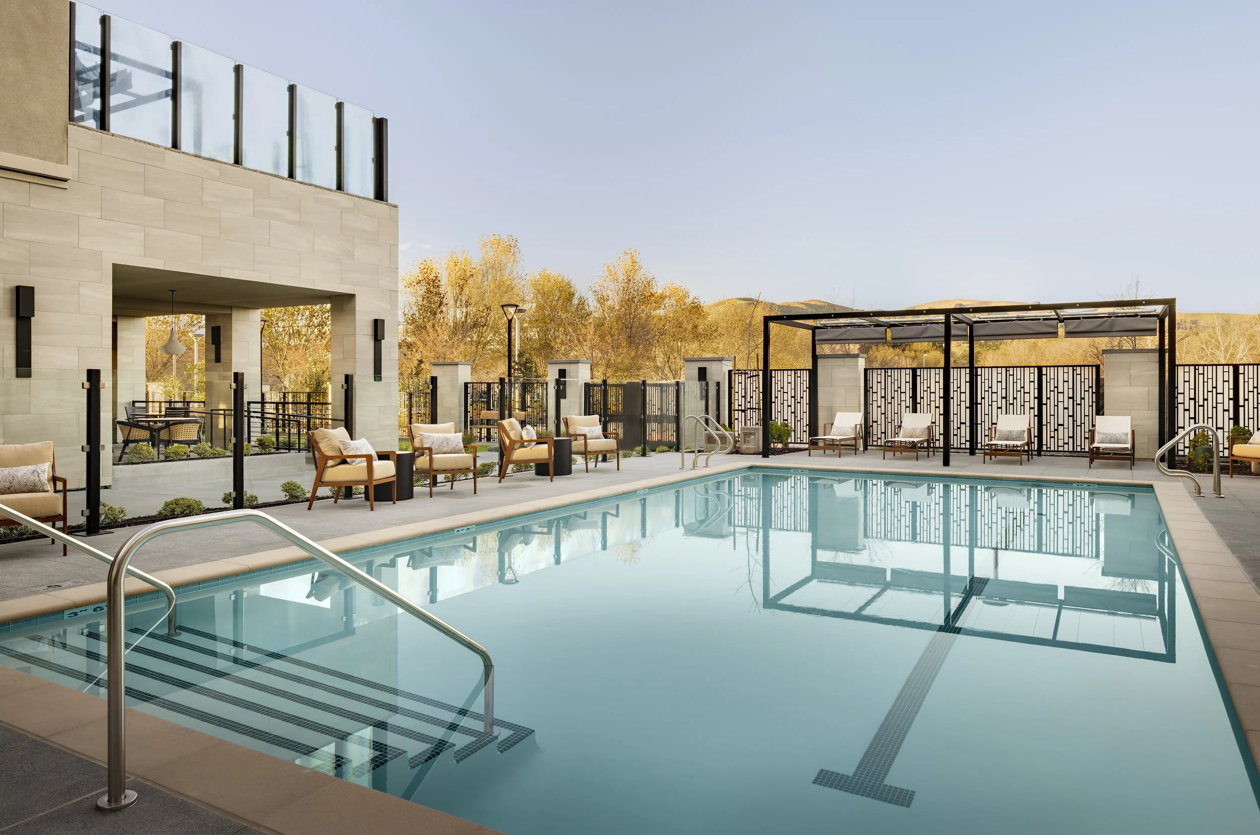 The pool terrace integrates planting, shade, and gathering spaces to create a resort-inspired outdoor environment that supports wellness and social connection. Credit: Zack Benson Images