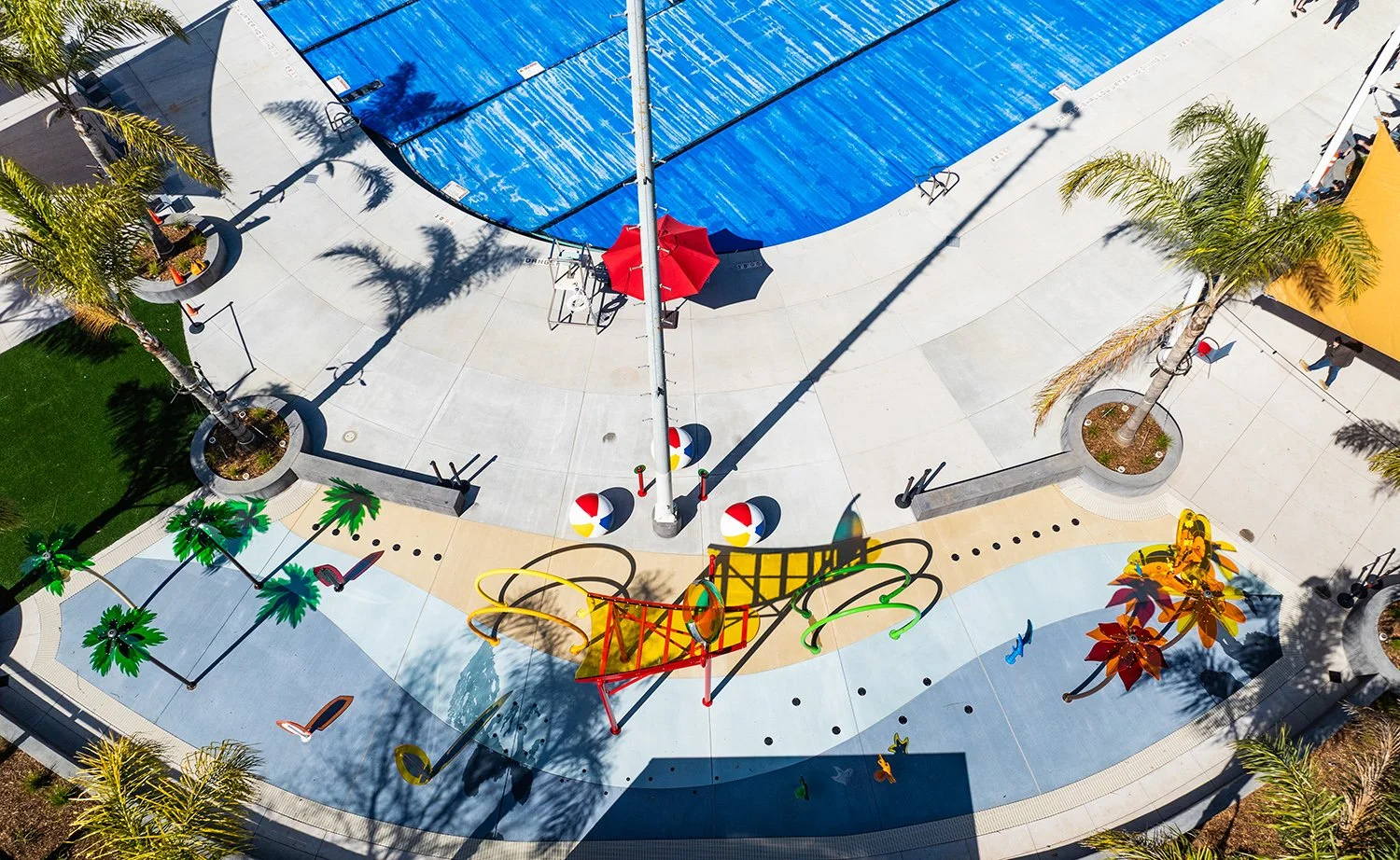 The design creates a beach-themed experience with palm trees, wave patterns, beach balls, and surfboards.